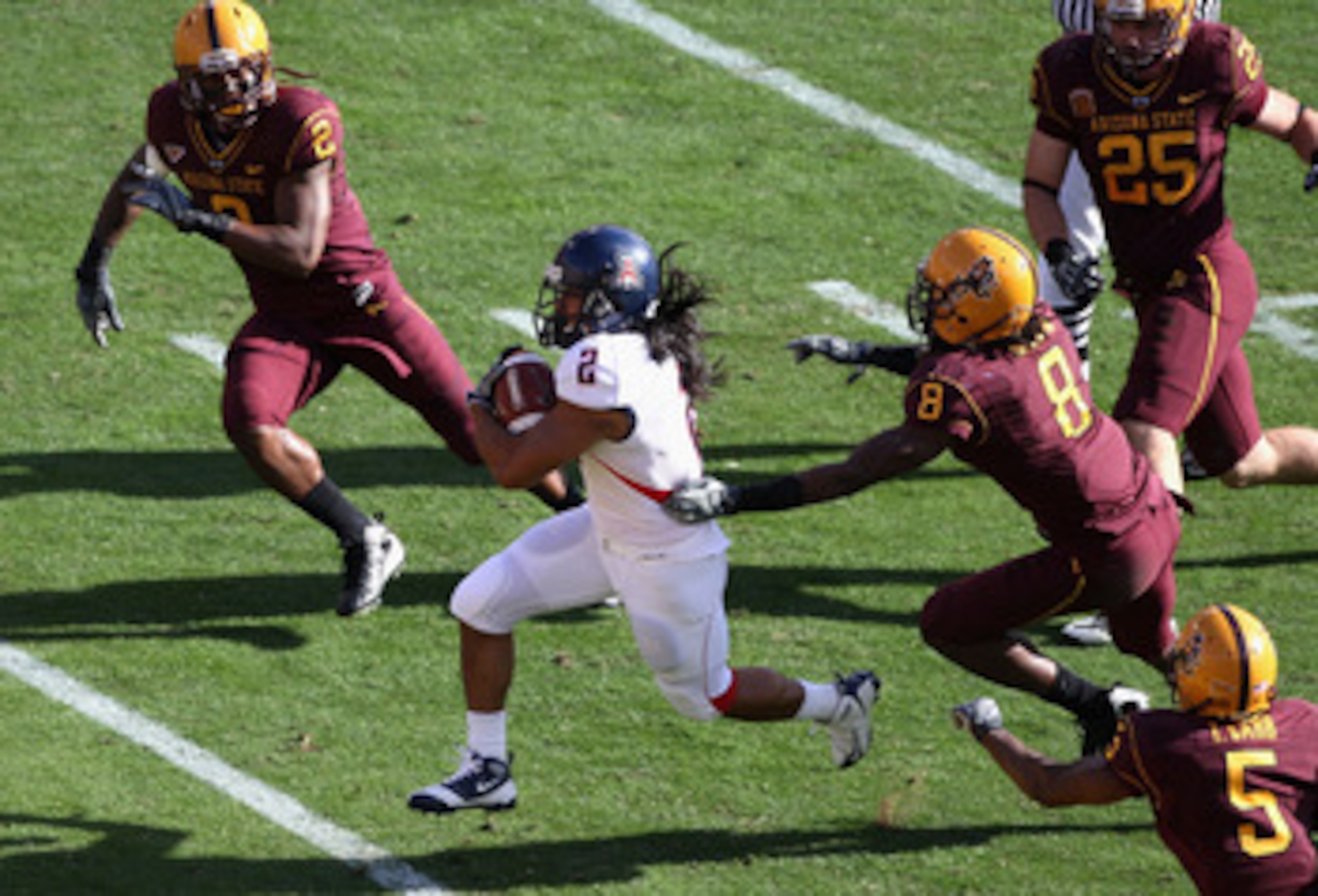 TEMPE, AZ - NOVEMBER 28:  Wide reciver Keola Antolin #2 of the Arizona Wildcats rushes for a 68 yard touchdown past Jarrell Holman #8 of the Arizona State Sun Devils during the college football game at Sun Devil Stadium on November 28, 2009 in Tempe, Ariz
