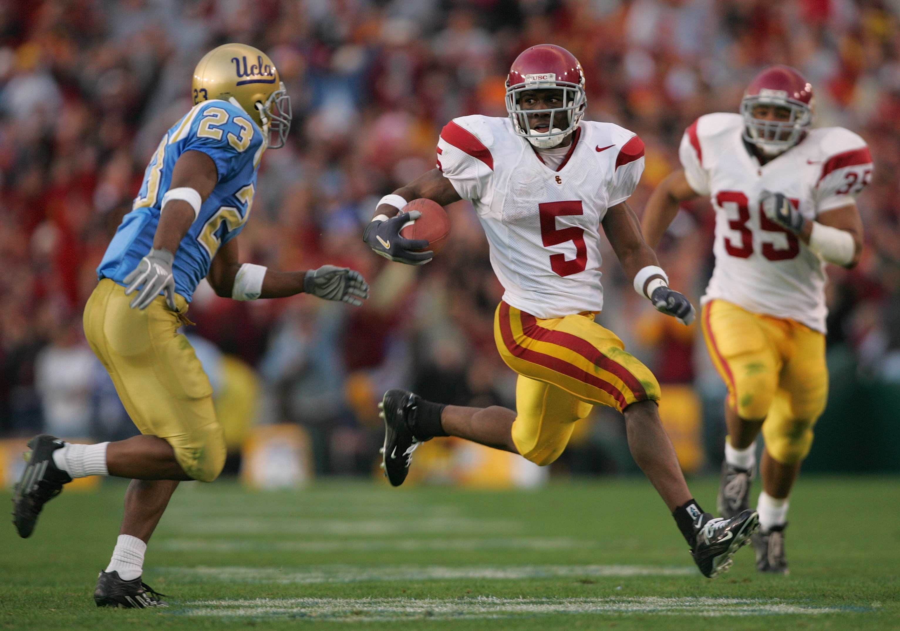 PASADENA, CA - DECEMBER 4:  Reggie Bush #5 of the USC Trojans attempts to evade Trey Brown #23 of the UCLA Bruins during the game on December 4, 2004 at the Rose Bowl in Pasadena, California.  USC won 29-24. (Photo by Harry How/Getty Images)
