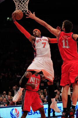 NEW YORK, NY - MARCH 30: Carmelo Anthony #7 of the New York Knicks shoots over Brook Lopez #11 of the New Jersey Nets at Madison Square Garden on March 30, 2011 in New York City. NOTE TO USER: User expressly acknowledges and agrees that, by downloading an
