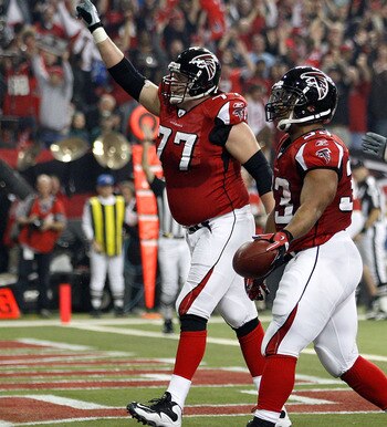 ATLANTA, GA - JANUARY 15:  (L-R) Tyson Clabo #77, Michael Turner #33 and Harvey Dahl #73 of the Atlanta Falcons celebrate after Turner scored a 12-yard rushing touchdown in the first quarter against the Green Bay Packers during their 2011 NFC divisional p