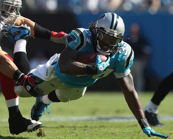 CHARLOTTE, NC - OCTOBER 24:  Travis LaBoy #54 of the San Francisco 49ers tackles DeAngelo Wiliams #34 of the Carolina Panthers during their game at Bank of America Stadium on October 24, 2010 in Charlotte, North Carolina.  (Photo by Streeter Lecka/Getty I