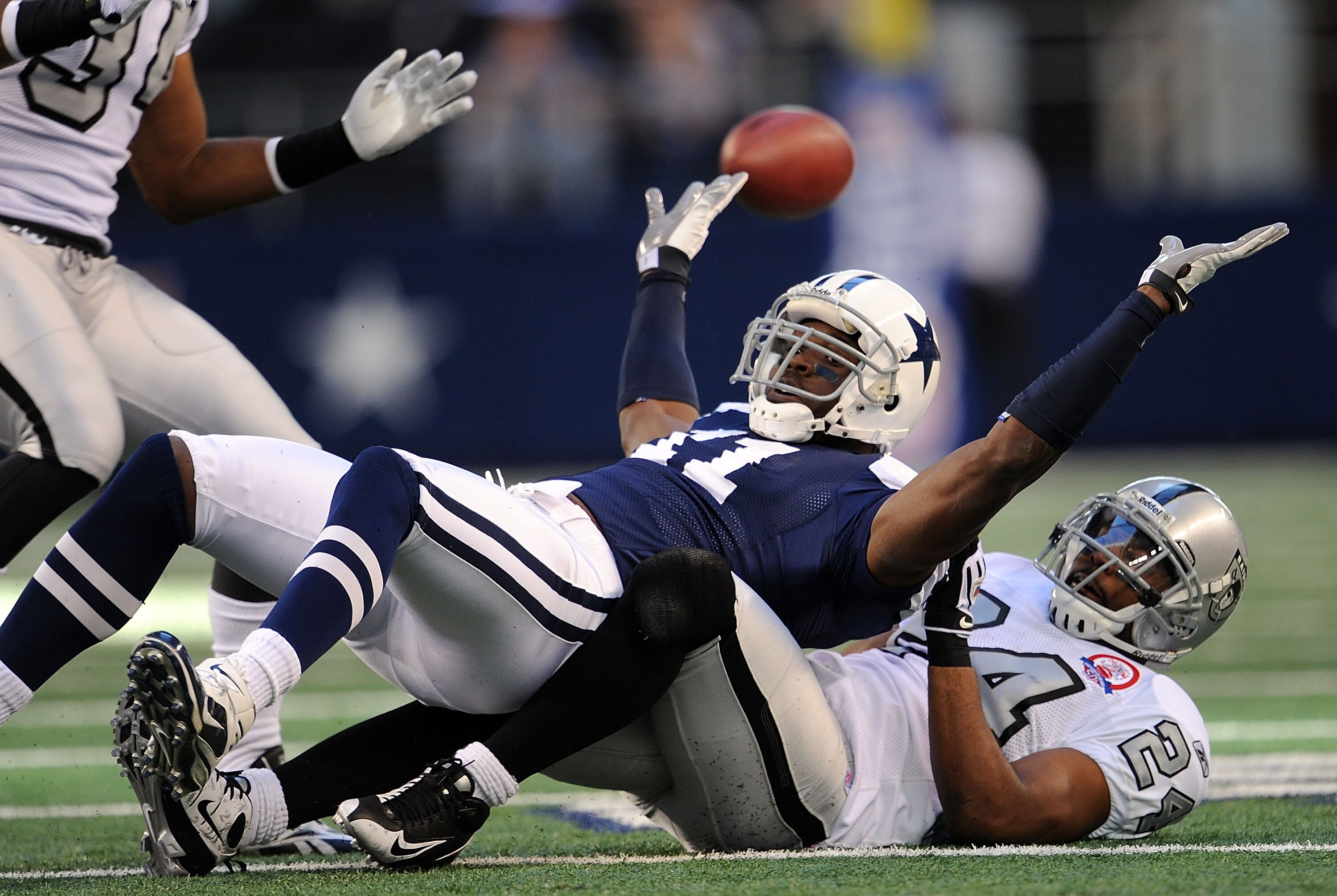 ARLINGTON, TX - NOVEMBER 26:  Wide receiver Roy Williams #11 of the Dallas Cowboys drops a pass while defended by Michael Huff #24 of the Oakland Raiders at Cowboys Stadium on November 26, 2009 in Arlington, Texas.  (Photo by Ronald Martinez/Getty Images)