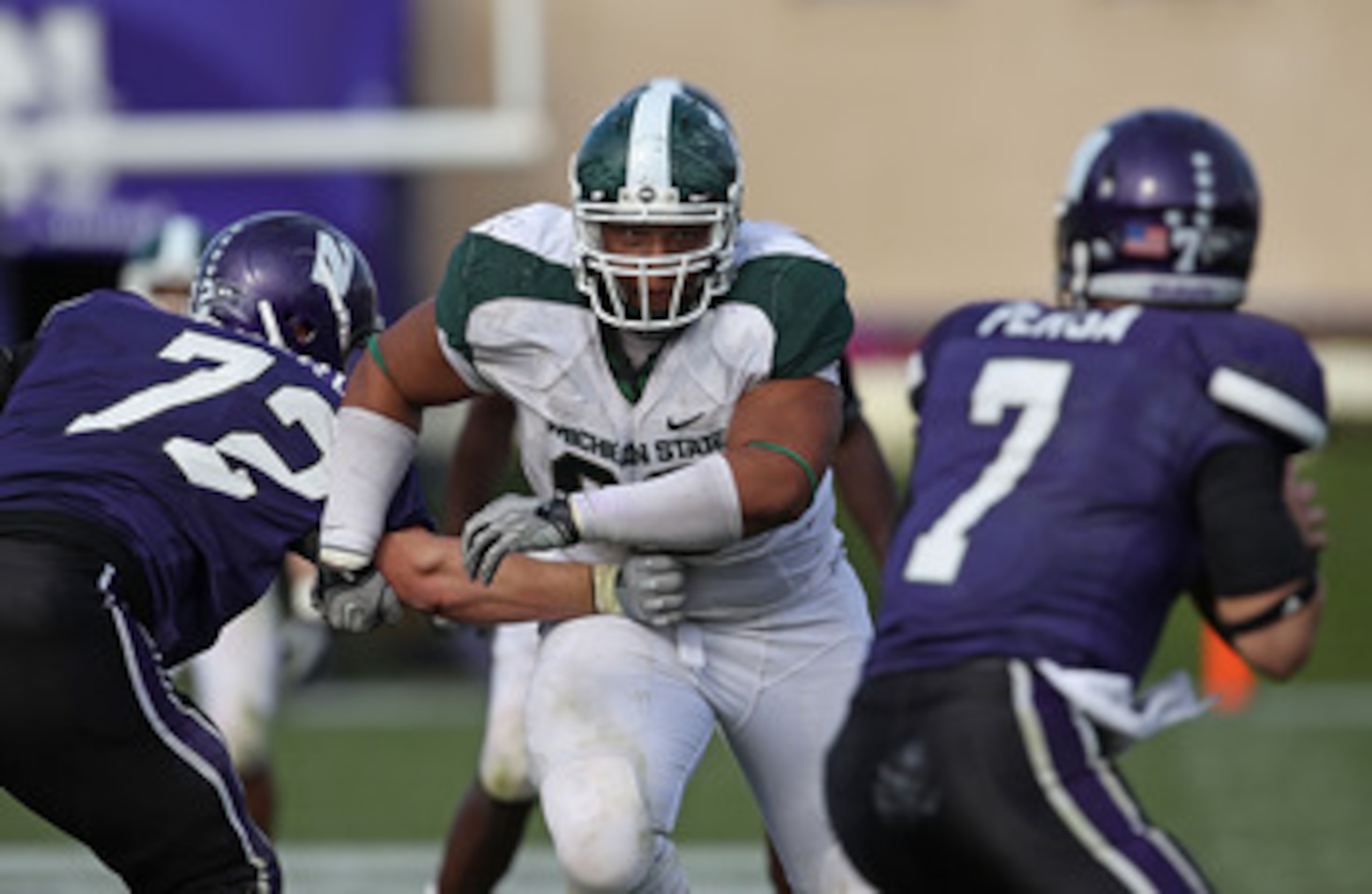 EVANSTON, IL - OCTOBER 23: Jerel Worthy #99 of the Michigan State Spartans moves past a block attempt by Brian Mulroe #72 of the Northwestern Wildcats with his sights set on Dan Persa #7 at Ryan Field on October 23, 2010 in Evanston, Illinois. Michigan St