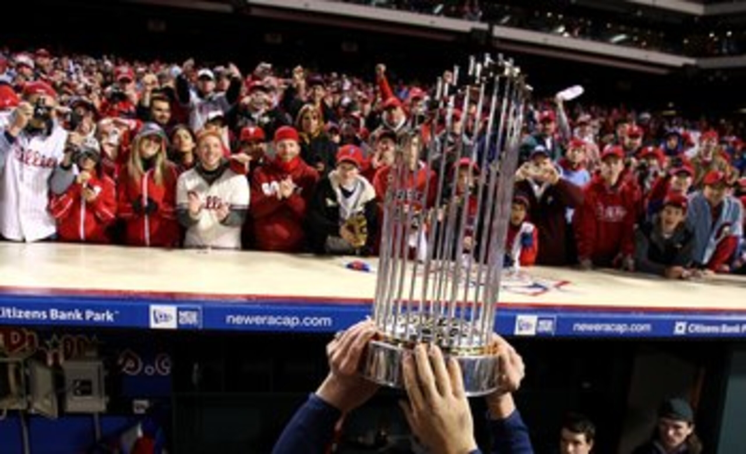 PHILADELPHIA - OCTOBER 29:  The World Series Championship trophy is held up in front of fans of the Philadelphia Phillies after they won 4-3 against the Tampa Bay Rays during the continuation of game five of the 2008 MLB World Series on October 29, 2008 a