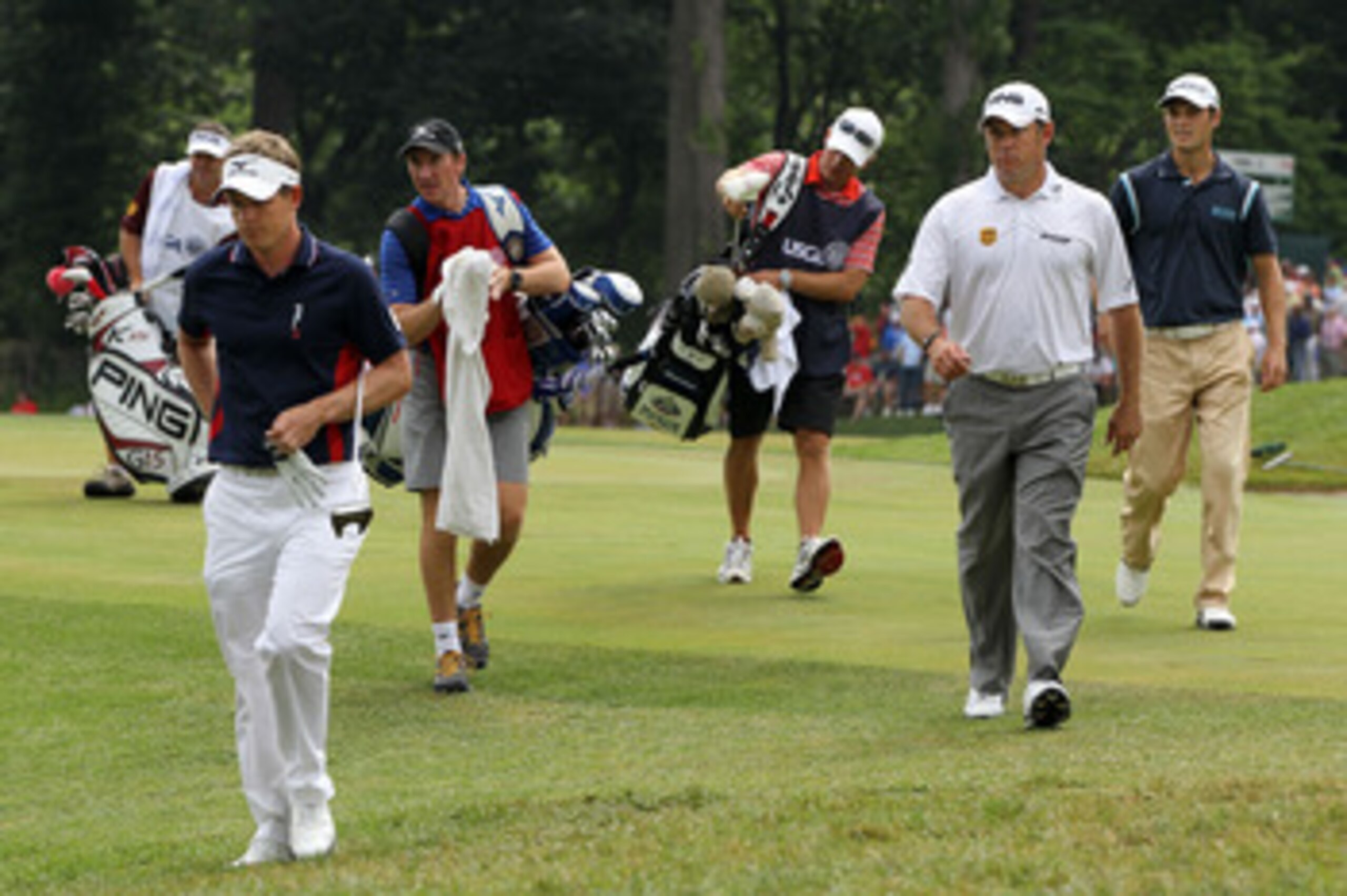BETHESDA, MD - JUNE 16:  (L-R) Luke Donald and Lee Westwood of England walk with Martin Kaymer of Germany and their caddies off the 18th green during the first round of the 111th U.S. Open at Congressional Country Club on June 16, 2011 in Bethesda, Maryla