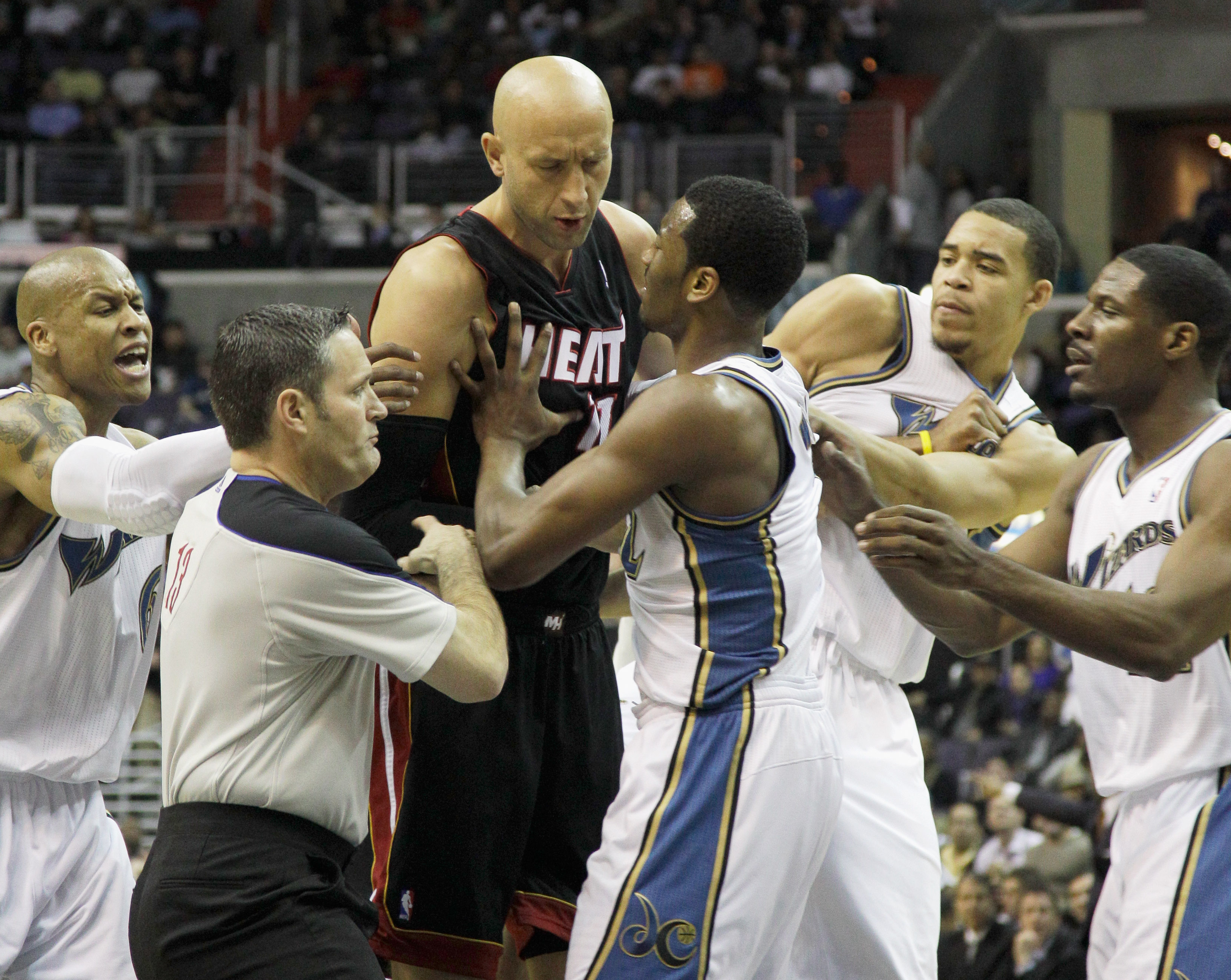 WASHINGTON, DC - MARCH 30: Zydrunas Ilgauskas #11 of the Miami Heat (C) and John Wall #2 of the Washington Wizards (R) are restrained by referee Monty McCutchen #13 (L) during the first half at the Verizon Center on March 30, 2011 in Washington, DC. Ilgau