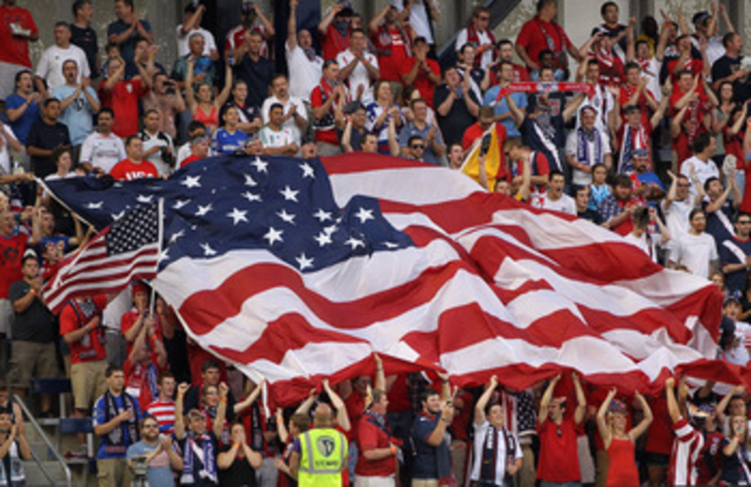 KANSAS CITY, KS - JUNE 14:  Fans cheer with a giant American flag prior to the start of the GoldCup game between the USA and Guadeloupe on June 14, 2011 at LiveStrong Sporting Park in Kansas City, Kansas.  (Photo by Jamie Squire/Getty Images)