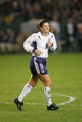 CARSON, CA - DECEMBER 8:  Forward Mia Hamm #9 of the USA smiles as she runs across the field during the 'Fan Celebration Tour' finale against Mexico on December 8, 2004 at The Home Depot Center in Carson, California.  Hamm would retire from the national t