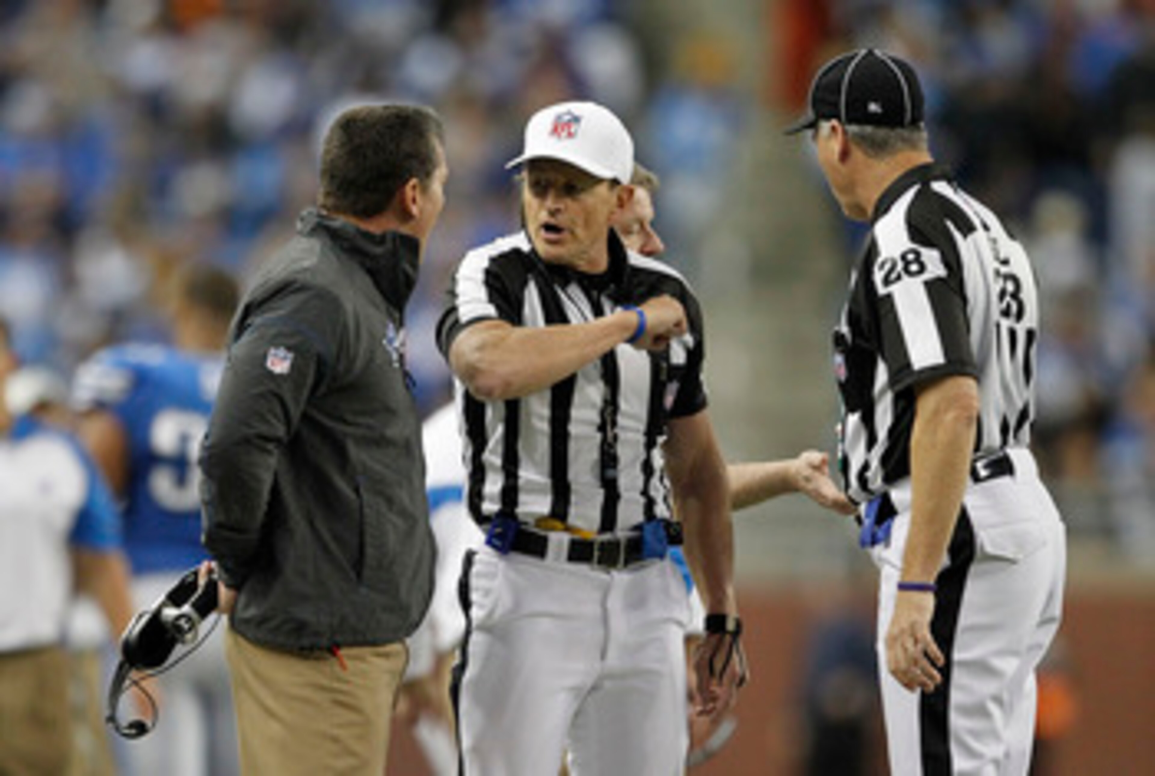 DETROIT - DECEMBER 05: Detroit Lions head coach Jim Schwartz argues an Unnecessary Roughness call on Ndamukong Suh #90 by NFL referee Ed Hochuli #85 during the fourth quarter of the game against the Chicago Bears at Ford Field on December 5, 2010 in Detro