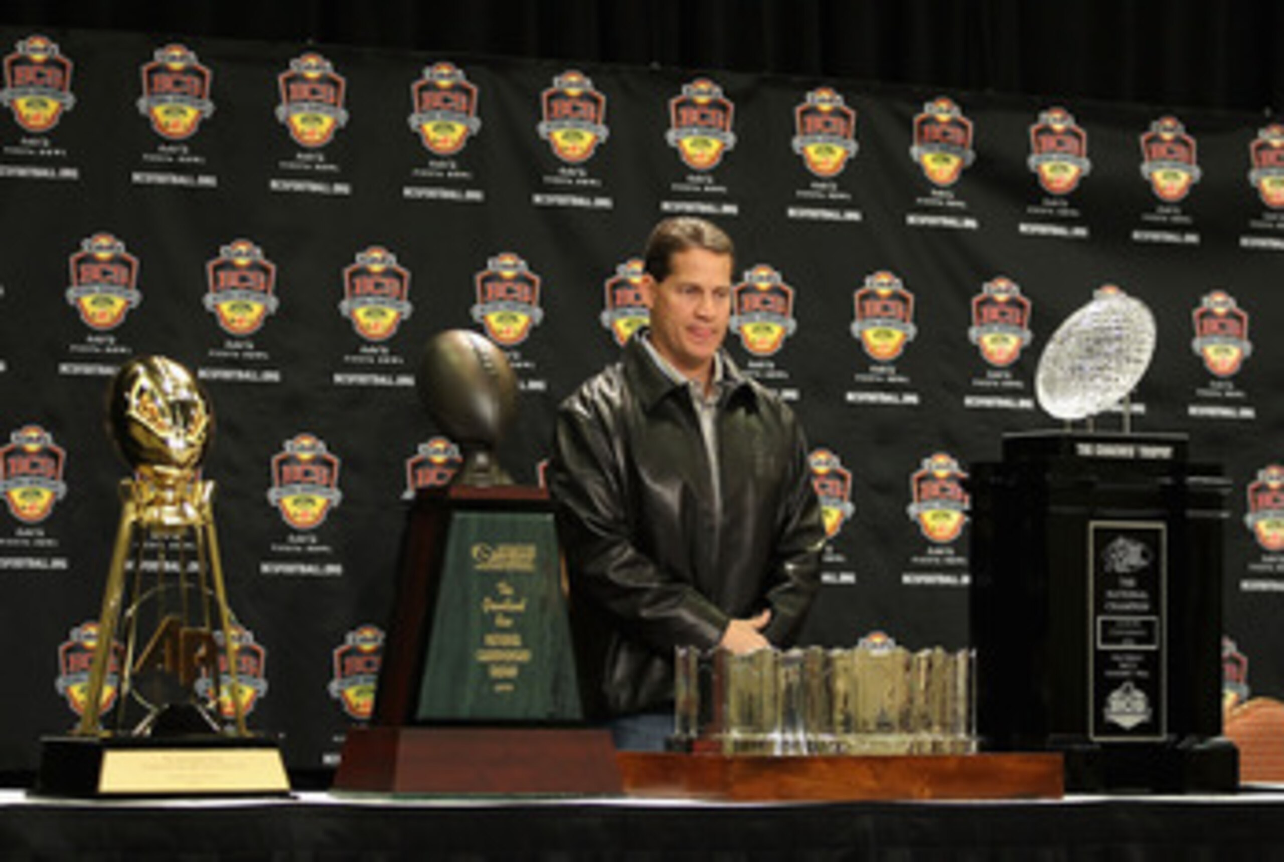 SCOTTSDALE, AZ - JANUARY 11:  Head coach Gene Chizik of the Auburn Tigers stands with the (L-R) Associated Press, Football Writers of America, MacArthur Bowl and the Coaches trophys during a press conference for the Tostitos BCS National Championship Game