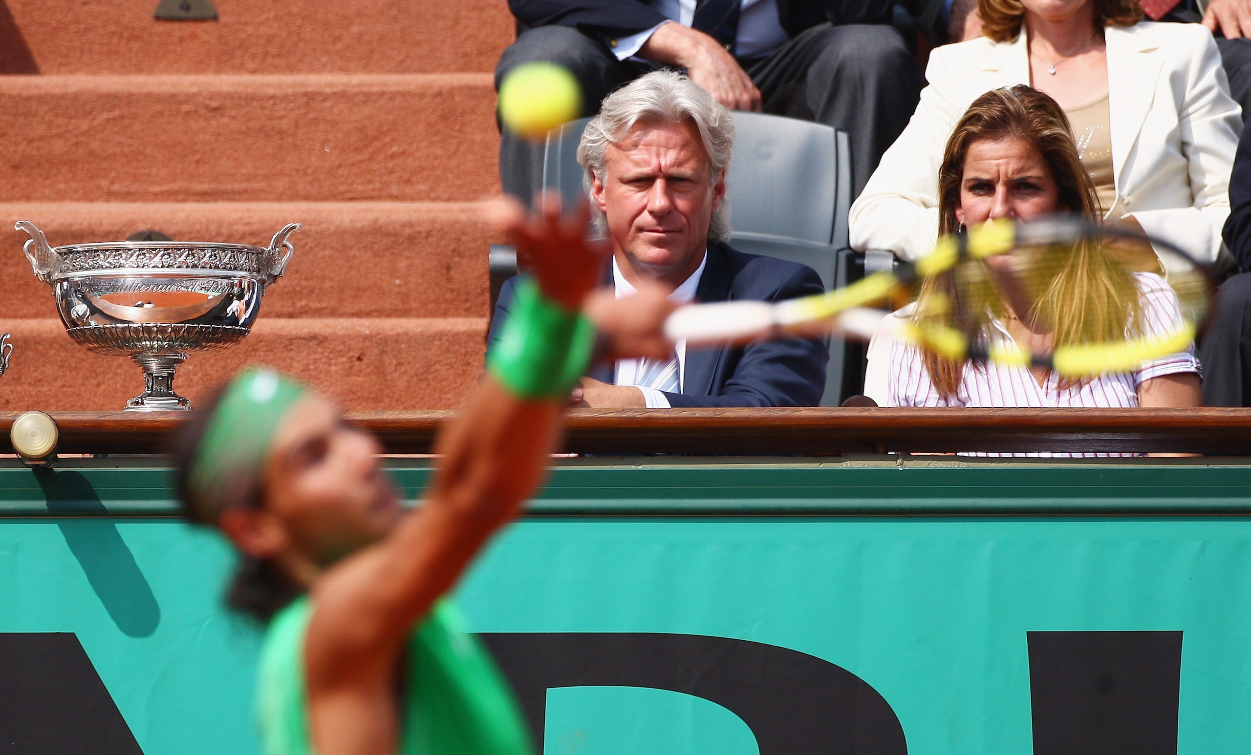 PARIS - JUNE 08:  Rafael Nadal of Spain serves as former player Bjorn Borg looks on during the Men's Singles Final match against Roger Federer of Switzerland on day fifteen of the French Open at Roland Garros on June 8, 2008 in Paris, France.  (Photo by M
