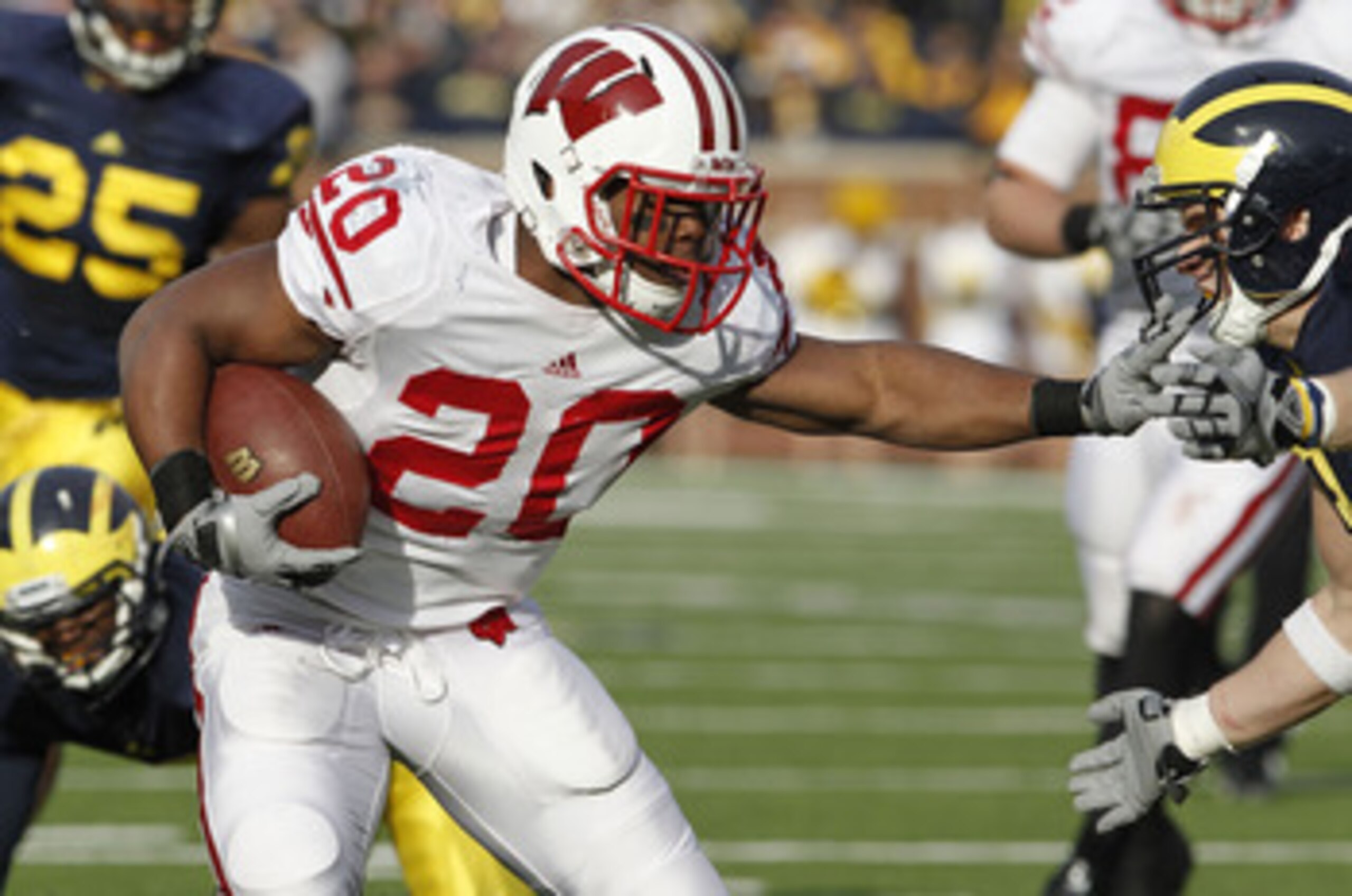 ANN ARBOR, MI - NOVEMBER 20:  James White #20 of the Wisconsin Badgers treies to get around the tackle of Jordan Kovacs #32 of the Michigan Wolverines at Michigan Stadium on November 20, 2010 in Ann Arbor, Michigan. Wisconson won the game 48-28.  (Photo b