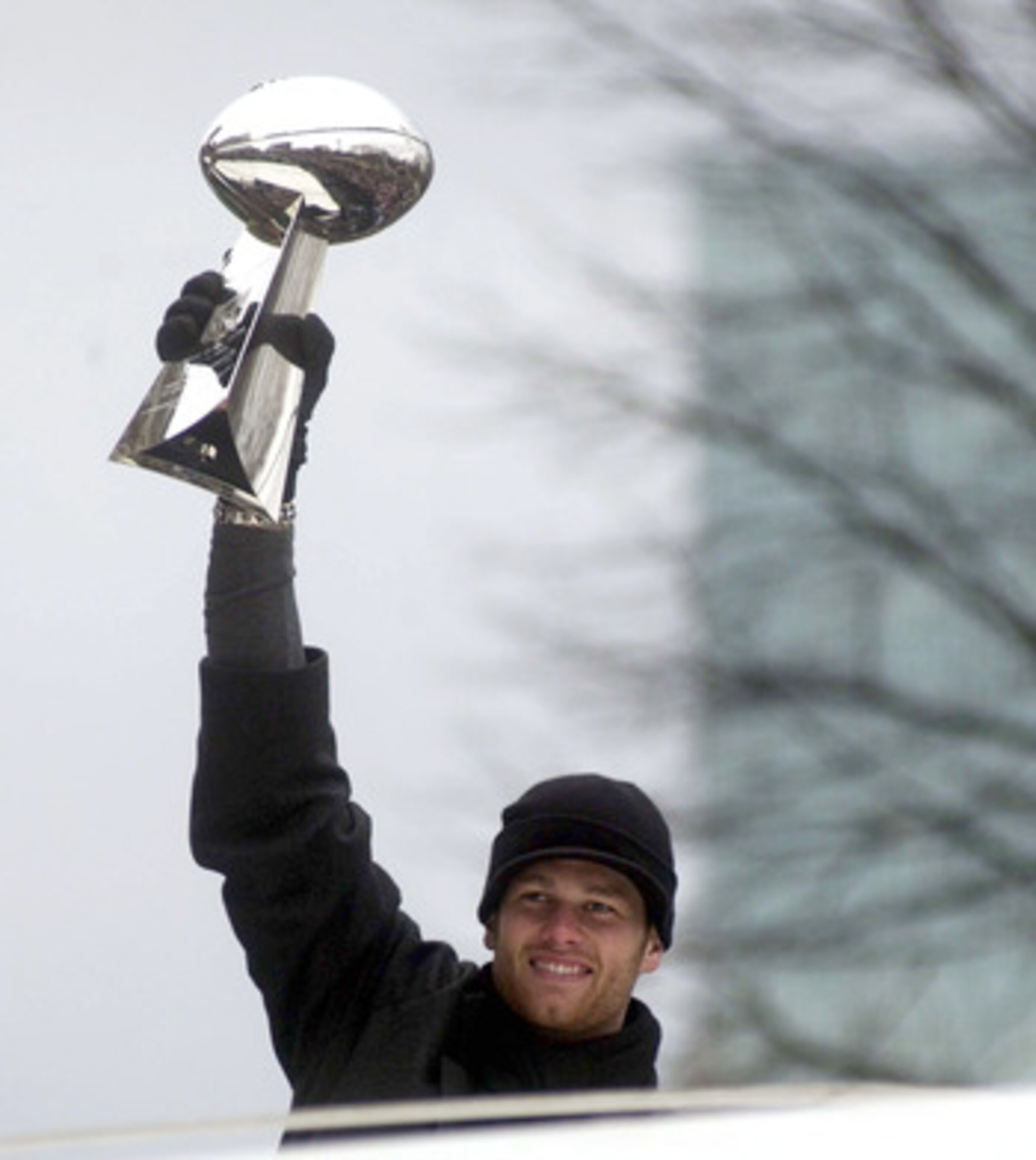 BOSTON, MA - FEBRUARY 3:  New England Patriots quarterback Tom Brady hoists the Lombardi Trophy during a victory parade February 3, 2004 in Boston, Massachusetts. The Patriots celebrated their second championship in three years today with a parade through