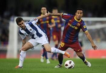SAN SEBASTIAN, SPAIN - APRIL 30:  Thiago of FC Barcelona (R) fights for the ball against Antoine Griezmann of Real Sociedad during the La Liga match between Real Sociedad and Barcelona at Estadio Anoeta on April 30, 2011 in San Sebastian, Spain. Real Soci