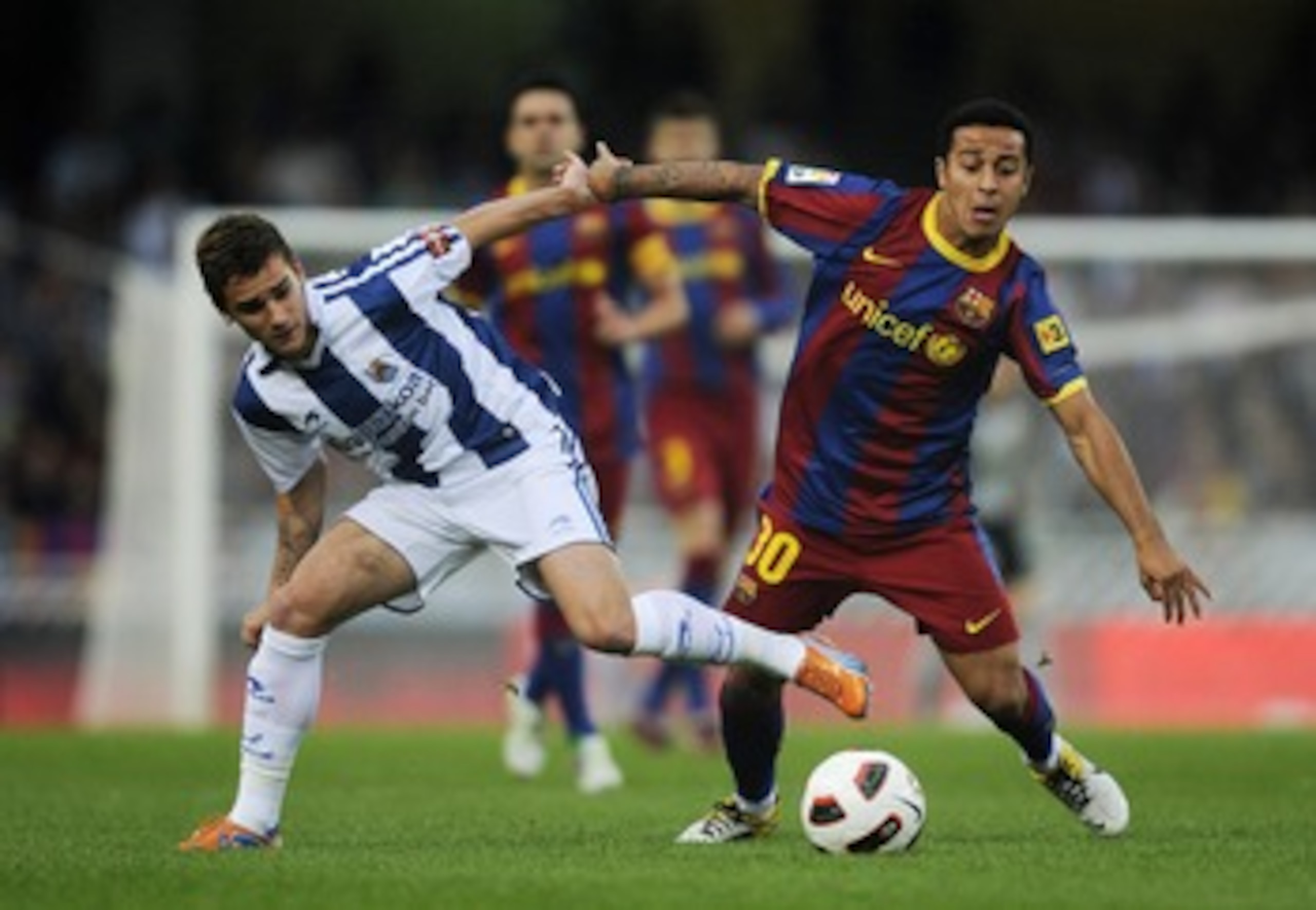 SAN SEBASTIAN, SPAIN - APRIL 30: Thiago of FC Barcelona (R) fights for the ball against Antoine Griezmann of Real Sociedad during the La Liga match between Real Sociedad and Barcelona at Estadio Anoeta on April 30, 2011 in San Sebastian, Spain. Real Soci SAN SEBASTIAN, SPAIN - APRIL 30: Thiago of FC Barcelona (R) fights for the ball against Antoine Griezmann of Real Sociedad during the La Liga match between Real Sociedad and Barcelona at Estadio Anoeta on April 30, 2011 in San Sebastian, Spain. Real Soci