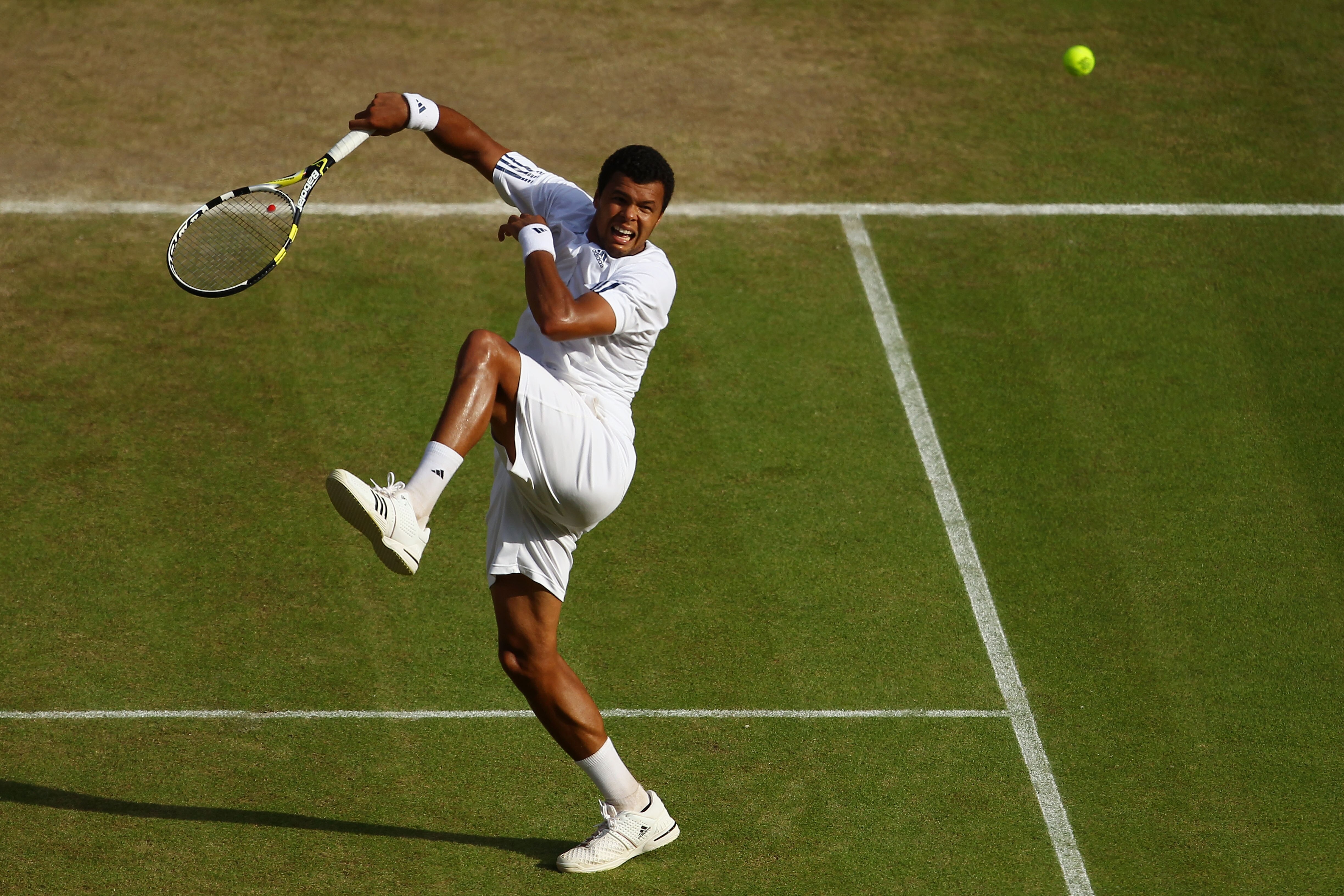 LONDON, ENGLAND - JUNE 30:  Jo-Wilfred Tsonga of France plays a shot during his Quarter Final match against Andy Murray of Great Britain on Day Nine of the Wimbledon Lawn Tennis Championships at the All England Lawn Tennis and Croquet Club on June 30, 201