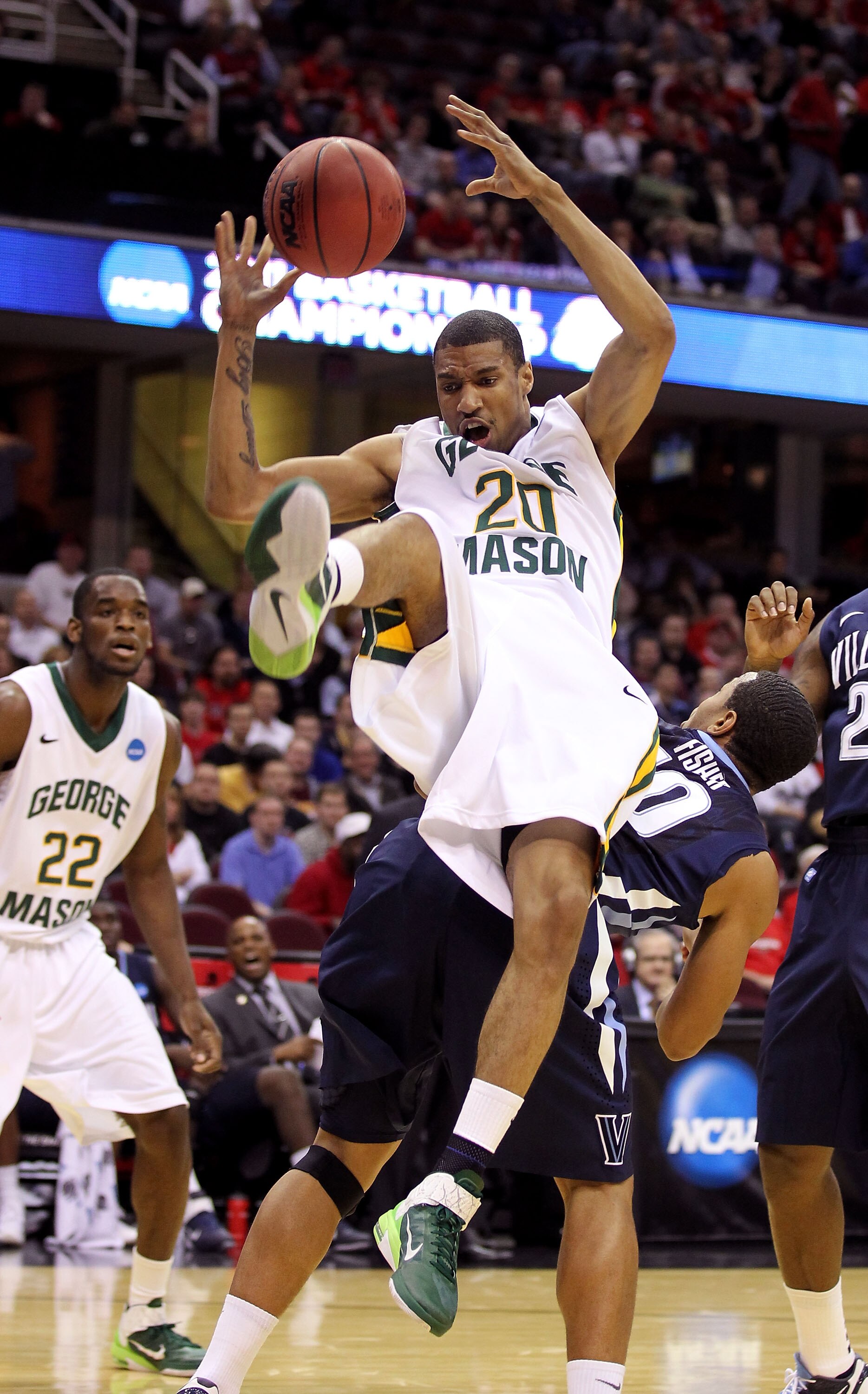 CLEVELAND, OH - MARCH 18:  Cam Long #20 of the George Mason Patriots falls after colliding with Corey Fisher #10 of the Villanova Wildcats during the second round of the 2011 NCAA men's basketball tournament at Quicken Loans Arena on March 18, 2011 in Cle