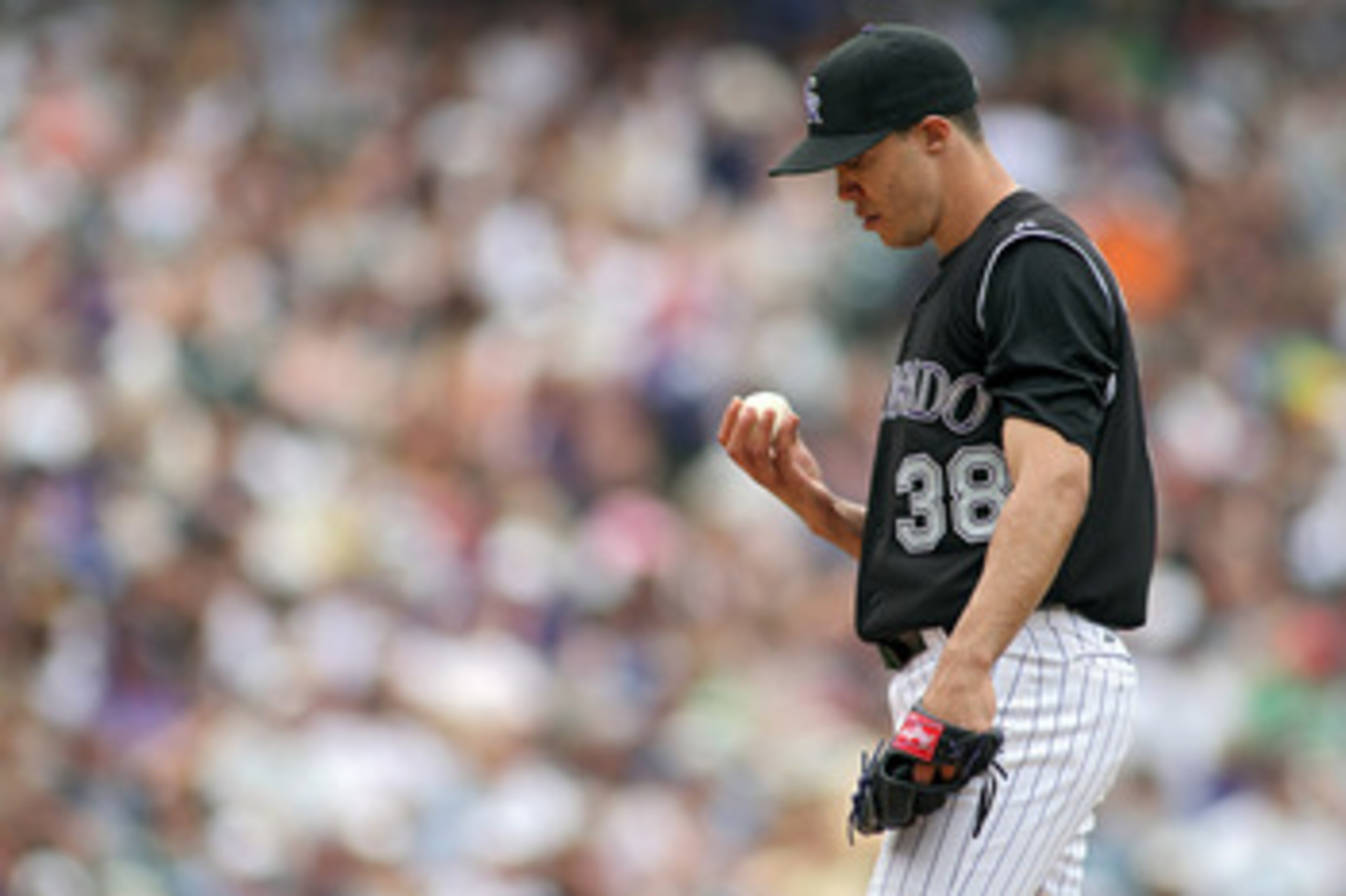 DENVER, CO - JUNE 12: Starting pitcher Ubaldo Jimenez #38 of the Colorado Rockies looks to his baseball before a pitch against the Los Angeles Dodgers on June 12, 2011 at Coors Field in Denver, Colorado. Jimenez gave up a grand slam home run in the game a
