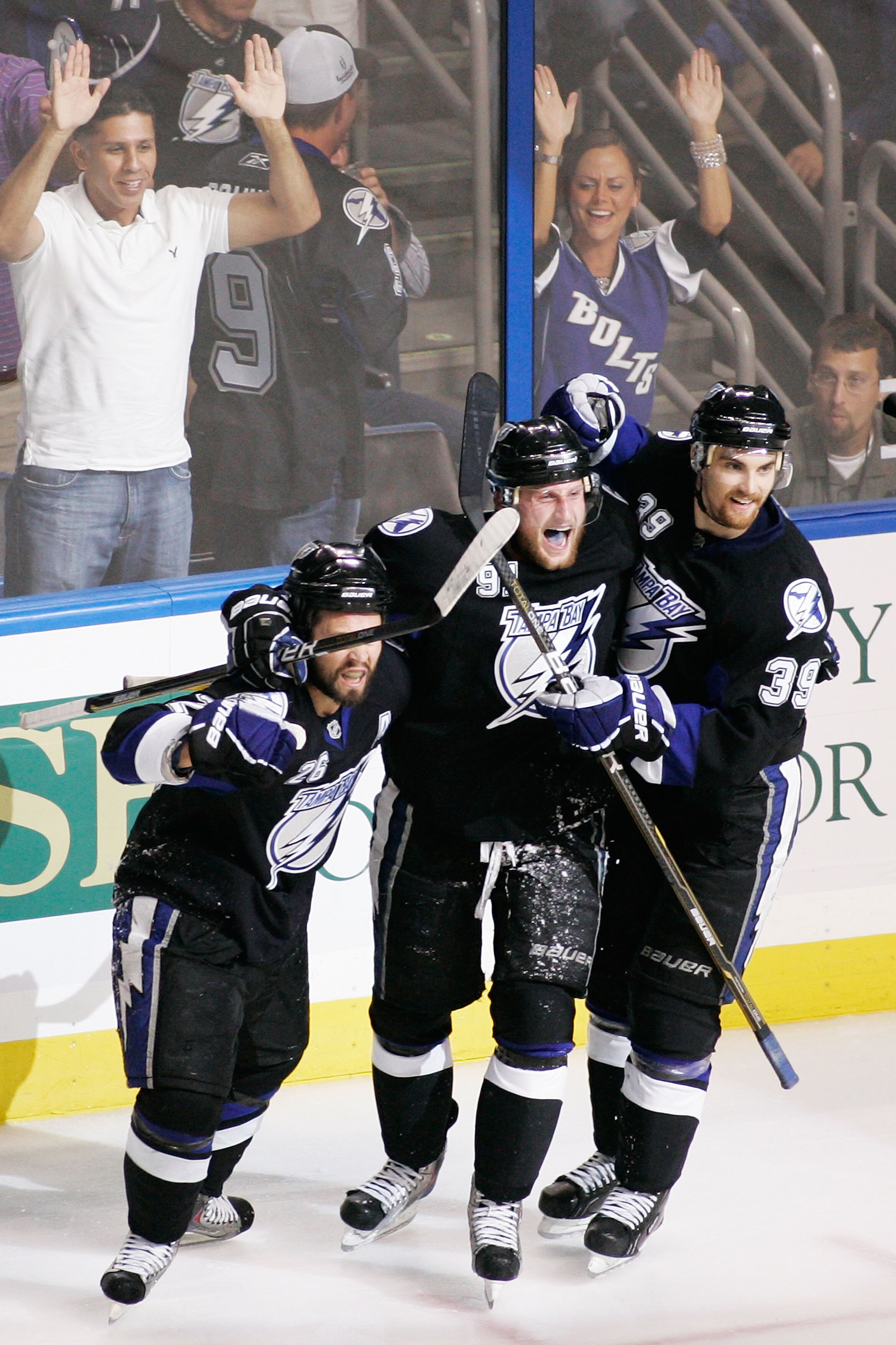 TAMPA, FL - MAY 25:  Martin St. Louis #26 celebrates his third period goal with Steven Stamkos #91 and Mike Lundin #39 of the Tampa Bay Lightning in Game Six of the Eastern Conference Finals against the Boston Bruins during the 2011 NHL Stanley Cup Playof