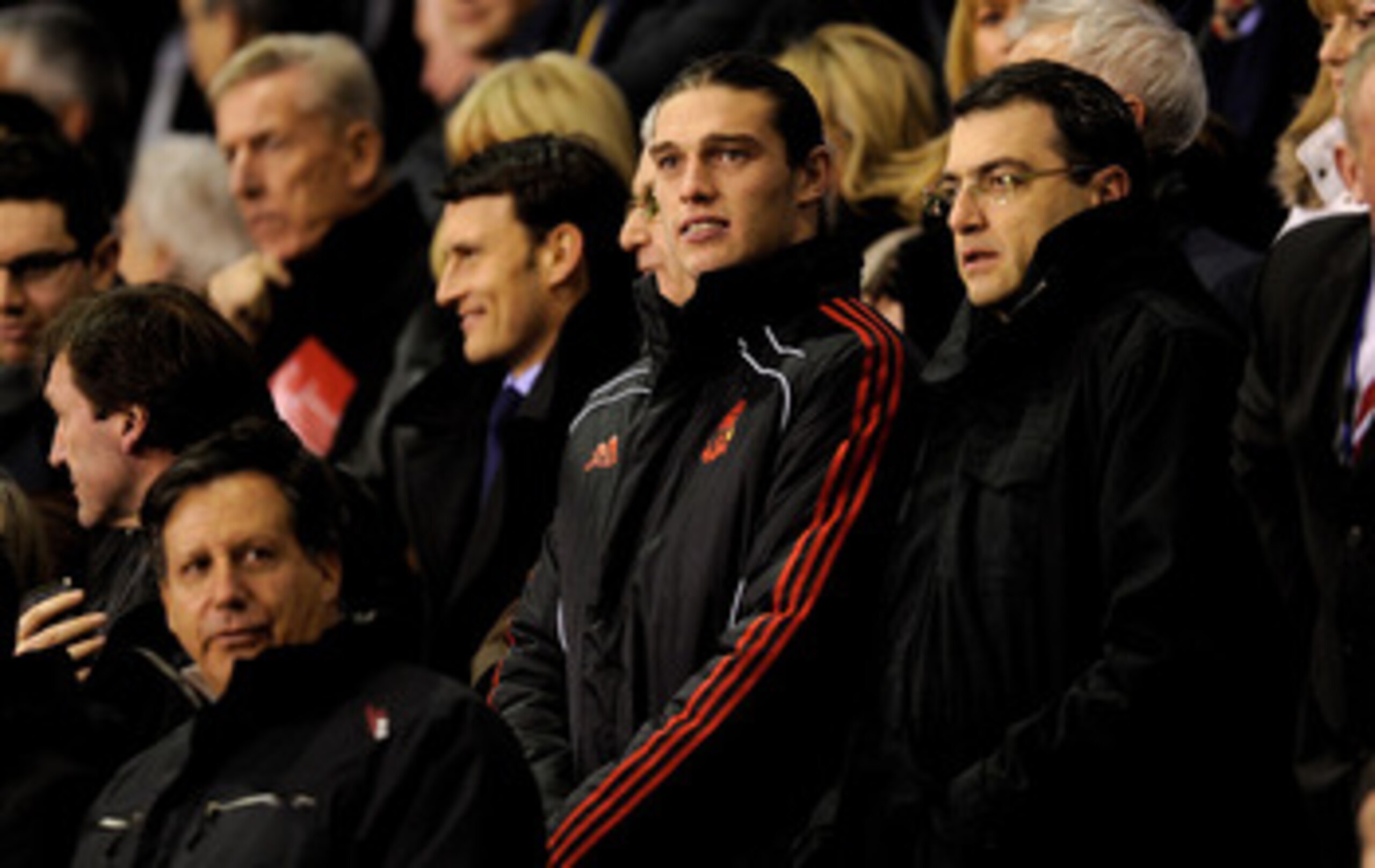 LIVERPOOL, ENGLAND - FEBRUARY 02:  New Liverpool signing Andy Carroll watches from the stands with Chairman Tom Werner (L) and Director of Football Strategy Damien Comolli (R) prior to the Barclays Premier League match between Liverpool and Stoke City at