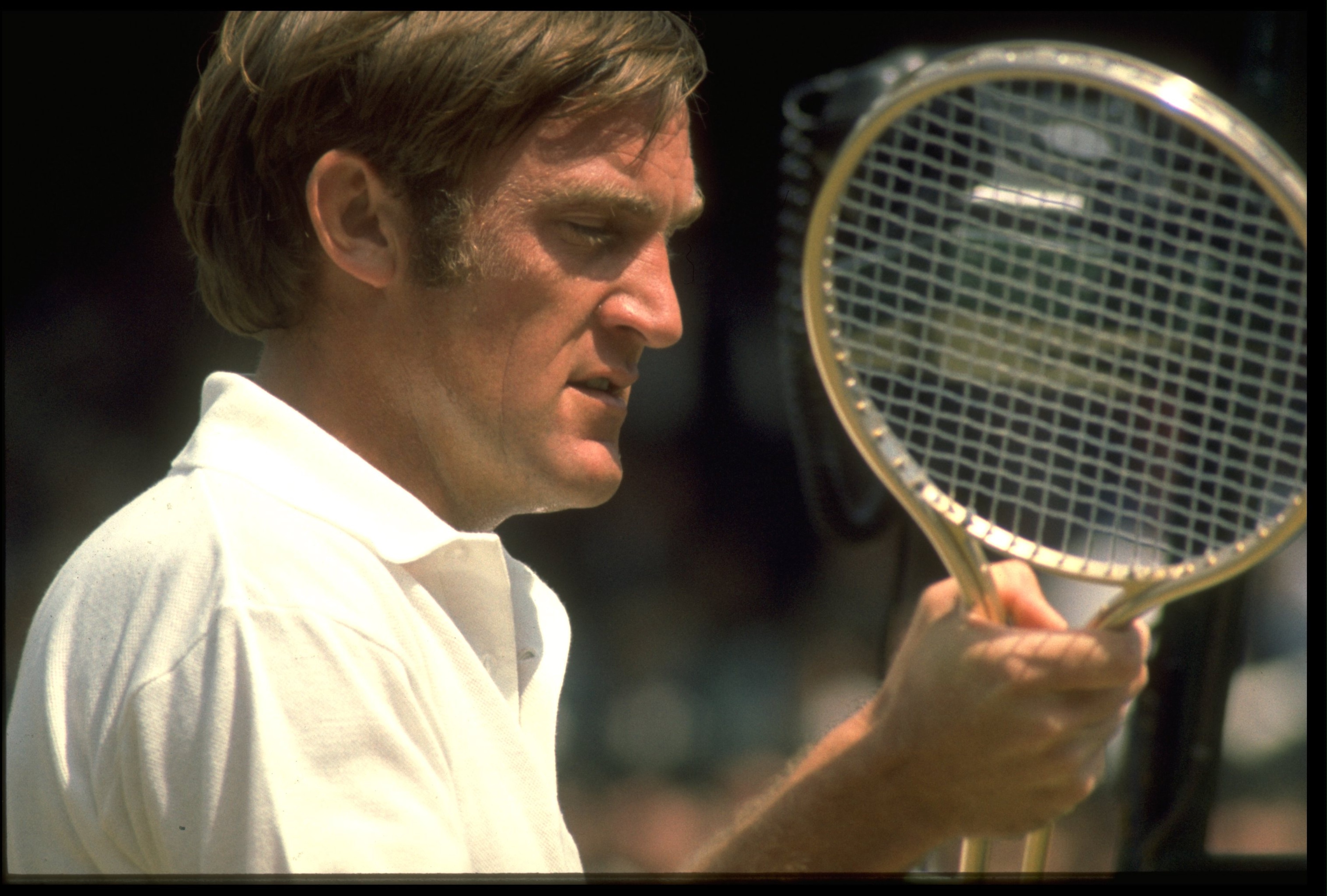 1970's: TONY ROCHE OF AUSTRALIA EXAMINES HIS RACQUET DURING A MATCH AT THE WIMBLEDON TENNIS CHAMPIONSHIPS. 1970's: TONY ROCHE OF AUSTRALIA EXAMINES HIS RACQUET DURING A MATCH AT THE WIMBLEDON TENNIS CHAMPIONSHIPS.