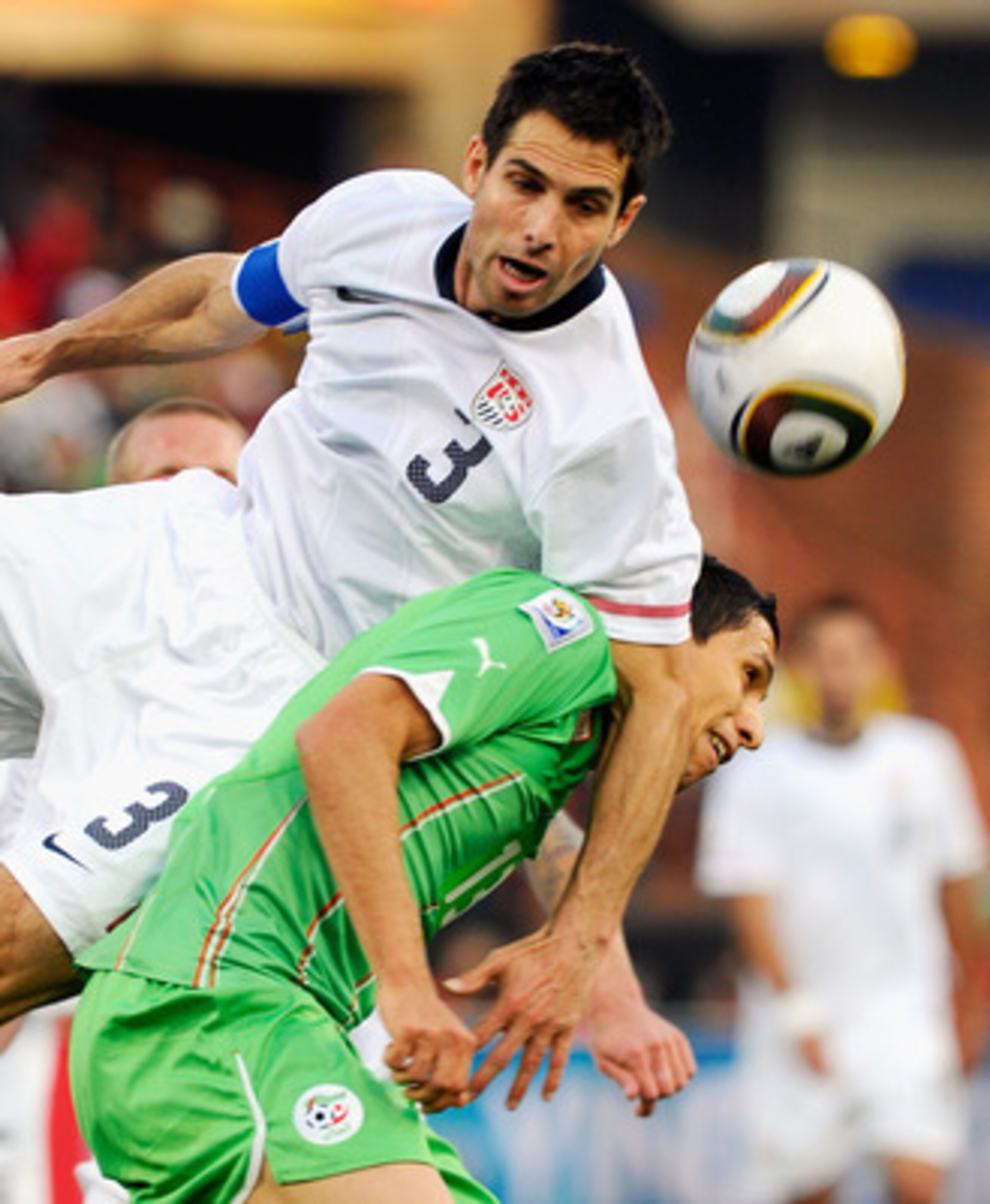 PRETORIA, SOUTH AFRICA - JUNE 23: Carlos Bocanegra of USA falls on top of Karim Matmour of  Algeria during the 2010 FIFA World Cup South Africa Group C match between USA and Algeria at the Loftus Versfeld Stadium on June 23, 2010 in Tshwane/Pretoria, Sout