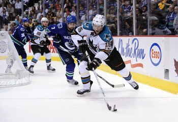 VANCOUVER, CANADA - MAY 24:  Dany Heatley #15 of the San Jose Sharks plays the puck away from Dan Hamhuis #2 of the Vancouver Canucks in Game Five of the Western Conference Finals during the 2011 Stanley Cup Playoffs at Rogers Arena on May 24, 2011 in Van