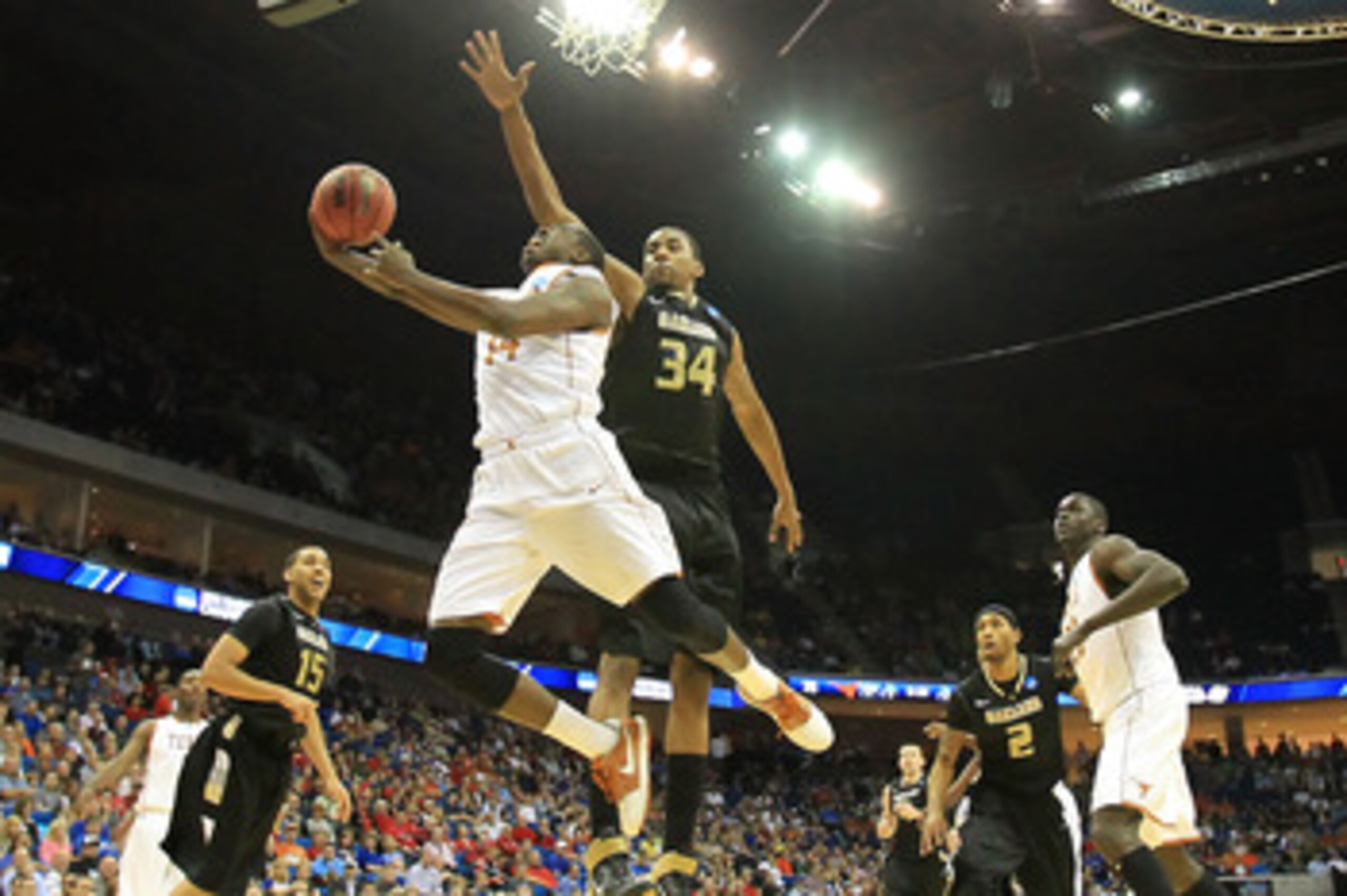 TULSA, OK - MARCH 18:  J'Covan Brown #14 of the Texas Longhorns goes up for a shot against Keith Benson #34 of the Oakland Golden Grizzlies during the second round of the 2011 NCAA men's basketball tournament at BOK Center on March 18, 2011 in Tulsa, Okla