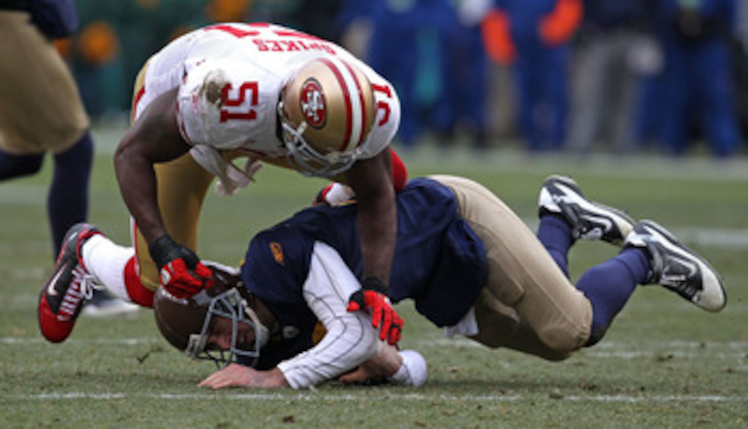 GREEN BAY, WI - DECEMBER 05: Takeo Spikes #51 of the San Francisco 49ers hits Aaron Rodgers #12 of the Green Bay Packers at Lambeau Field on December 5, 2010 in Green Bay, Wisconsin. The Packers defeated the 49ers 34-16. (Photo by Jonathan Daniel/Getty Im