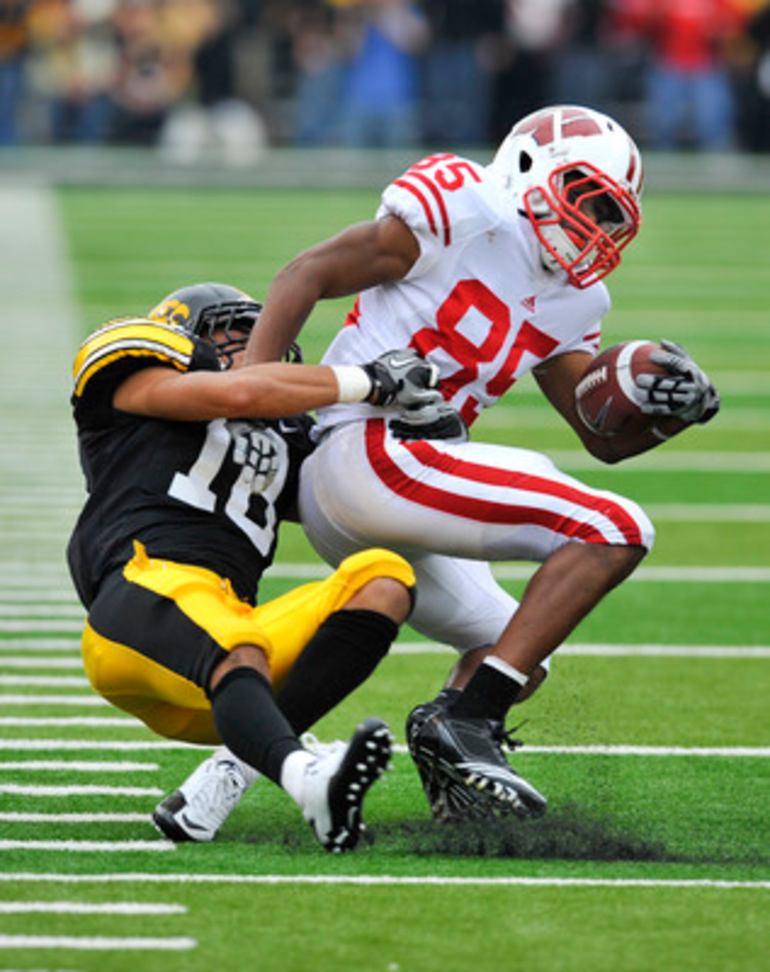 IOWA CITY, IA - OCTOBER 23- Defensive back Micah Hyde #18 of the University of Iowa Hawkeyes tackles wide receiver David Gilbreath #85 of the Wisconsin Badgers during the second half of play at Kinnick Stadium on October 23, 2010 in Iowa City, Iowa. Wisco IOWA CITY, IA - OCTOBER 23- Defensive back Micah Hyde #18 of the University of Iowa Hawkeyes tackles wide receiver David Gilbreath #85 of the Wisconsin Badgers during the second half of play at Kinnick Stadium on October 23, 2010 in Iowa City, Iowa. Wisco