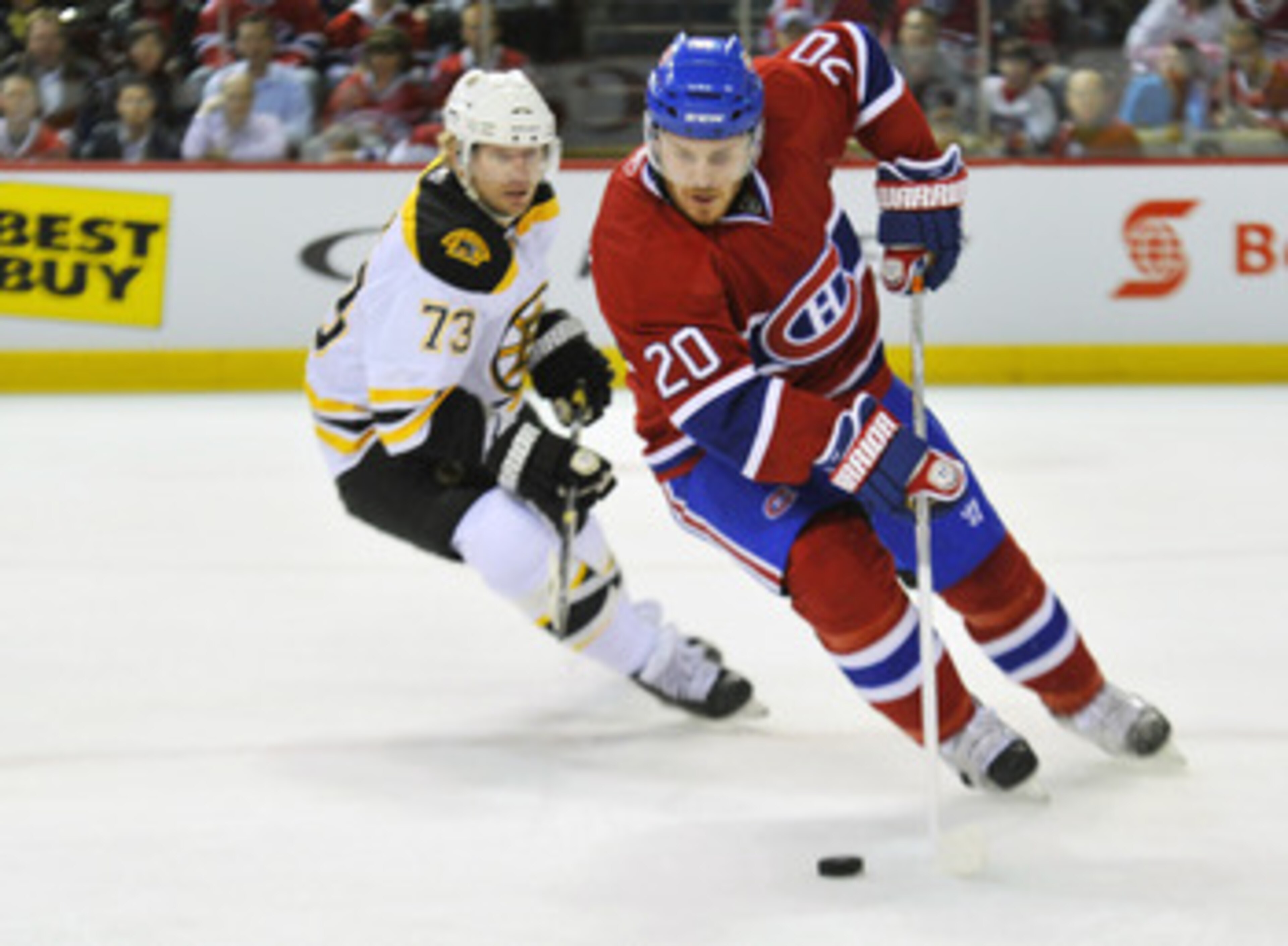 MONTREAL, QC - APRIL 18:  James Wisniewski #20 of the Montreal Canadiens turns up ice with the puck while being pursued by Michael Ryder #73 of the Boston Bruins in Game Three of the Eastern Conference Quarterfinals during the 2011 NHL Stanley Cup Playoff