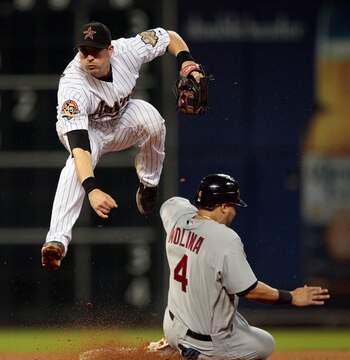 HOUSTON - AUGUST 31:  Shortstop Tommy Manzella #12 of the Houston Astros leaps to avoid Yadier Molina #4 of the St. Louis Cardinals as he relays the throw against the St.Louis Cardinals at Minute Maid Park on August 31, 2010 in Houston, Texas.  (Photo by