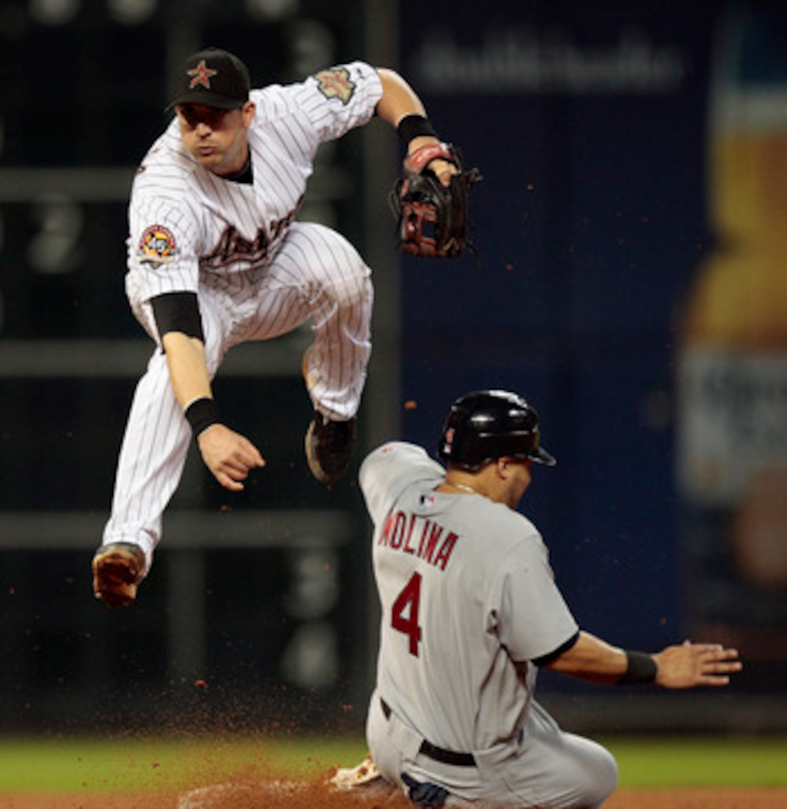 HOUSTON - AUGUST 31: Shortstop Tommy Manzella #12 of the Houston Astros leaps to avoid Yadier Molina #4 of the St. Louis Cardinals as he relays the throw against the St.Louis Cardinals at Minute Maid Park on August 31, 2010 in Houston, Texas. (Photo by HOUSTON - AUGUST 31: Shortstop Tommy Manzella #12 of the Houston Astros leaps to avoid Yadier Molina #4 of the St. Louis Cardinals as he relays the throw against the St.Louis Cardinals at Minute Maid Park on August 31, 2010 in Houston, Texas. (Photo by