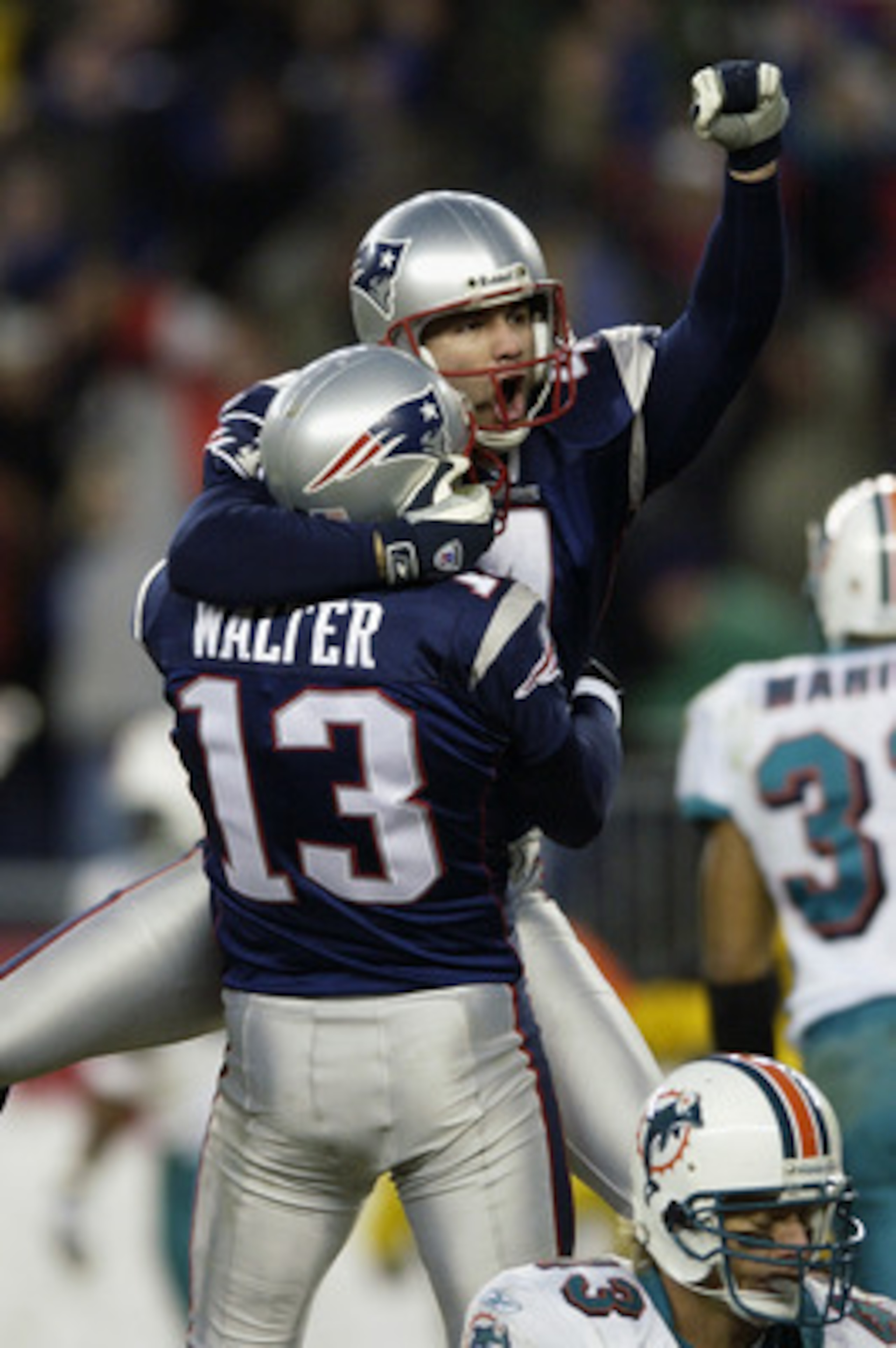 FOXBORO, MA - DECEMBER 29:  Adam Vinatieri #4 is lifted up by kick holder Ken Walter #13 of the New England Patriots after Vinatieri kicked a game-winning field goal in overtime to beat the Miami Dolphins at Gillette Stadium on December 29, 2002 in Foxbor