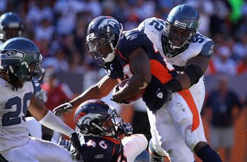 DENVER - SEPTEMBER 19:  Running back Knowshon Moreno #27 of the Denver Broncos is stopped by defensive tackle Brandon Mebane #92 of the Seattle Seahawks at INVESCO Field at Mile High on September 19, 2010 in Denver, Colorado. The Broncos defeated the Seah