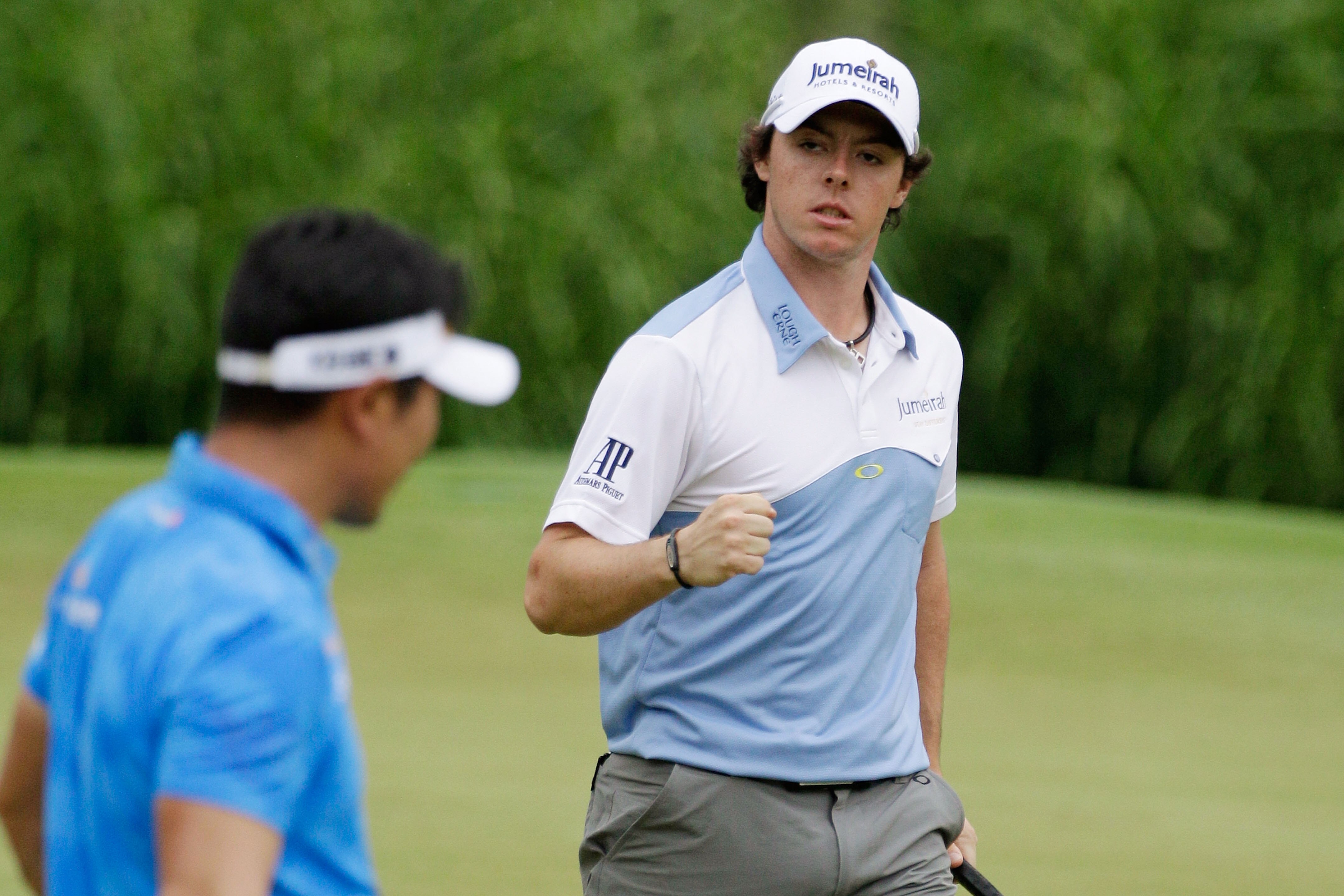 BETHESDA, MD - JUNE 18:  Rory McIlroy of Northern Ireland celebrates a birdie putt on the 11th green as Y.E. Yang of South Korea looks on during the third round of the 111th U.S. Open at Congressional Country Club on June 18, 2011 in Bethesda, Maryland.