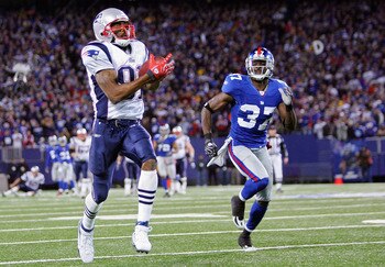 EAST RUTHERFORD, NJ - DECEMBER 29:  Randy Moss  #81 of the New England Patriots runs after a catch for his 23rd touchdown of the season breaking the all time season high for touchdowns in a season against James Butler #37 of the New York Giants on Decembe
