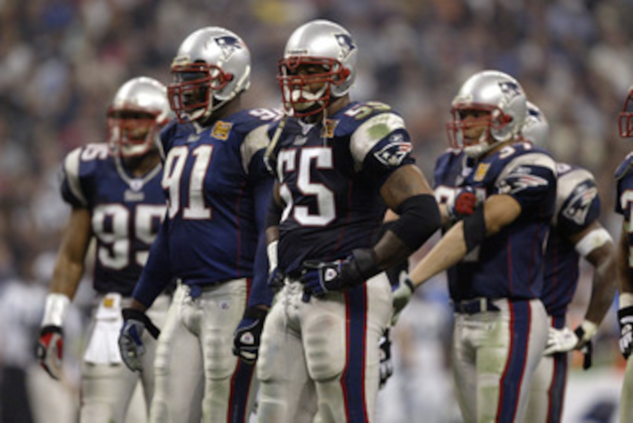HOUSTON - FEBRUARY 1:  Defensive end Willie McGinest #55 of the New England Patriots stands next to defensive end Bobby Hamilton #91 in Super Bowl XXXVIII against the Carolina Panthers at Reliant Stadium on February 1, 2004 in Houston, Texas.  The Patriot