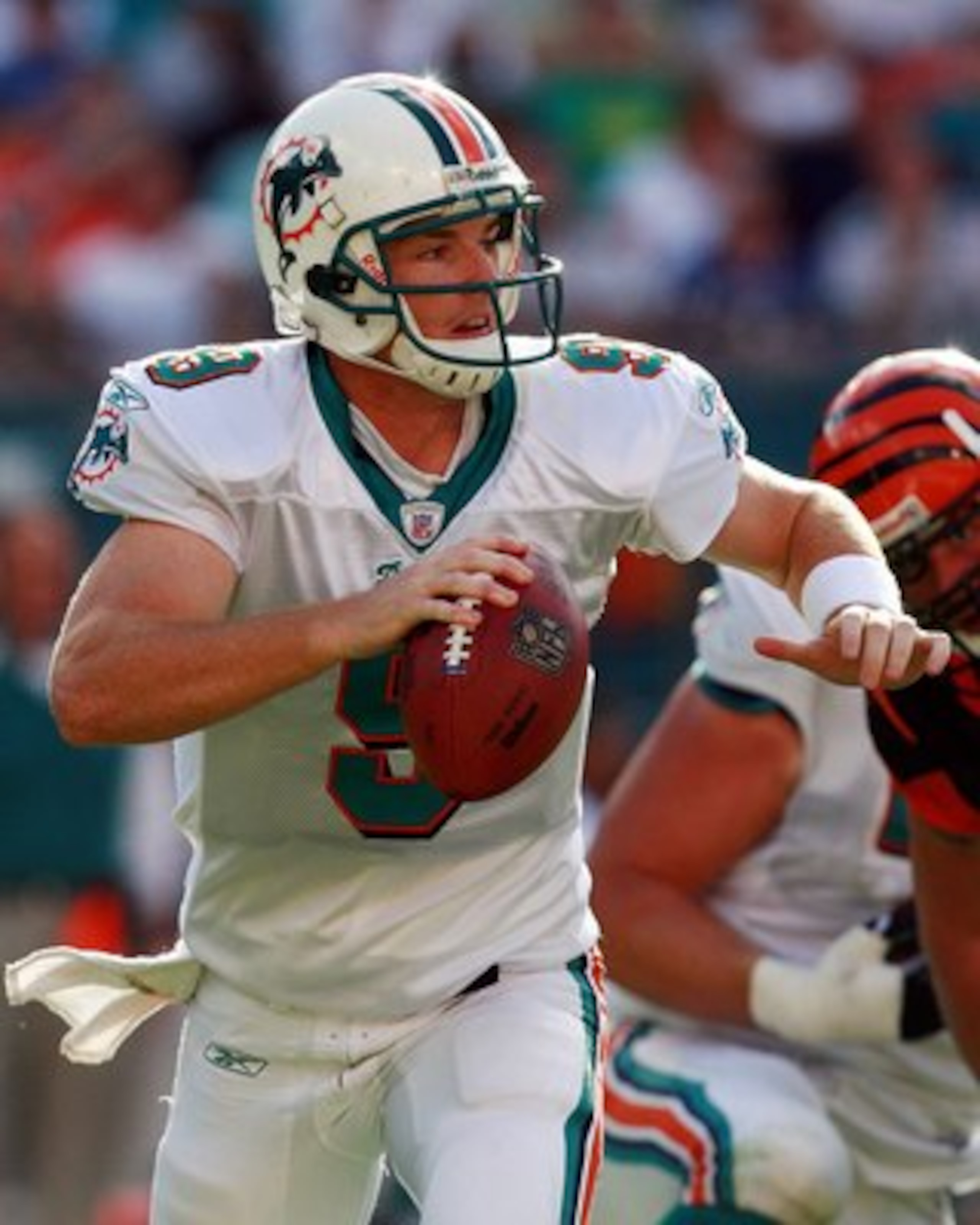 MIAMI - DECEMBER 30:  Quarterback John Beck #9 of the Miami Dolphins scrambles while being chased by defensive end Justin Smith #90 of the Cincinnati Bengals at Dolphin Stadium on December 30, 2007 in Miami, Florida. The Bengals defeated the Dolphins 38-2