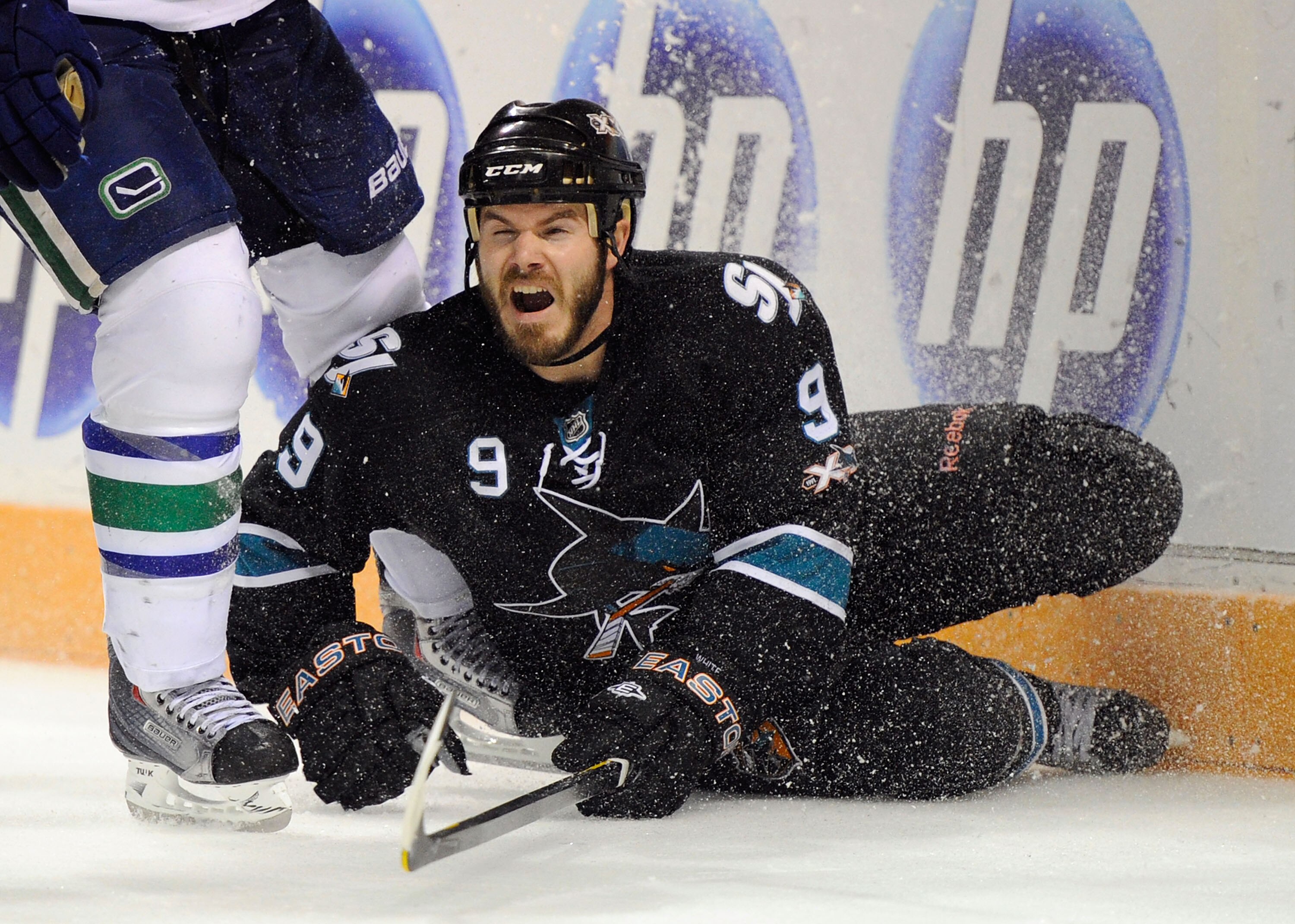 SAN JOSE, CA - MAY 20:  Ian White #9 of the San Jose Sharks falls to the ice near the end boards in Game Three of the Western Conference Finals against the Vancouver Canucks during the 2011 Stanley Cup Playoffs at HP Pavilion on May 20, 2011 in San Jose,