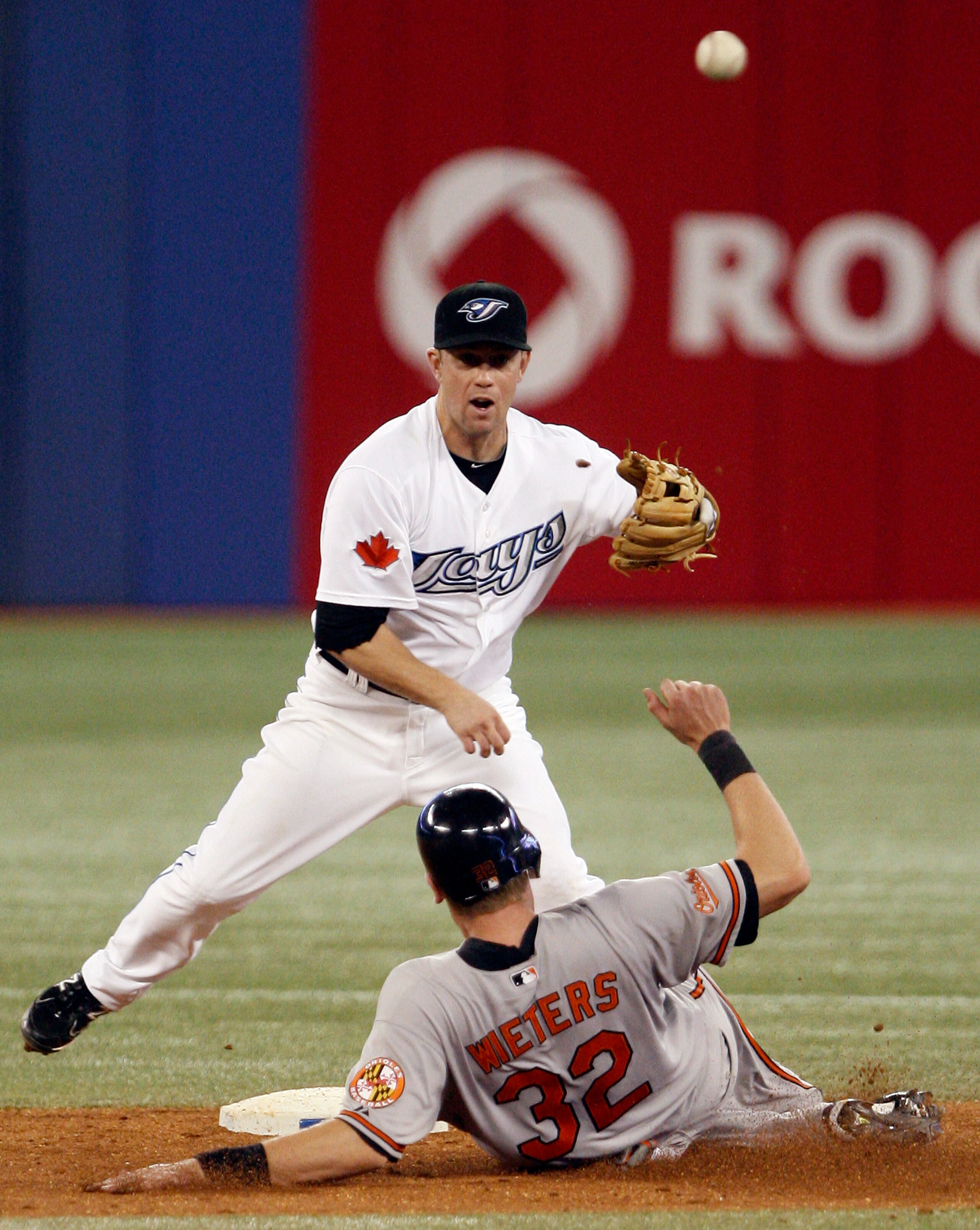 TORONTO, CANADA - JUNE 15:  Aaron Hill #2 of the Toronto Blue Jays makes the double play on Matt Wieters #32 of the Baltimore Orioles during MLB action at The Rogers Centre June 15, 2011 in Toronto, Ontario, Canada. (Photo by Abelimages/Getty Images)