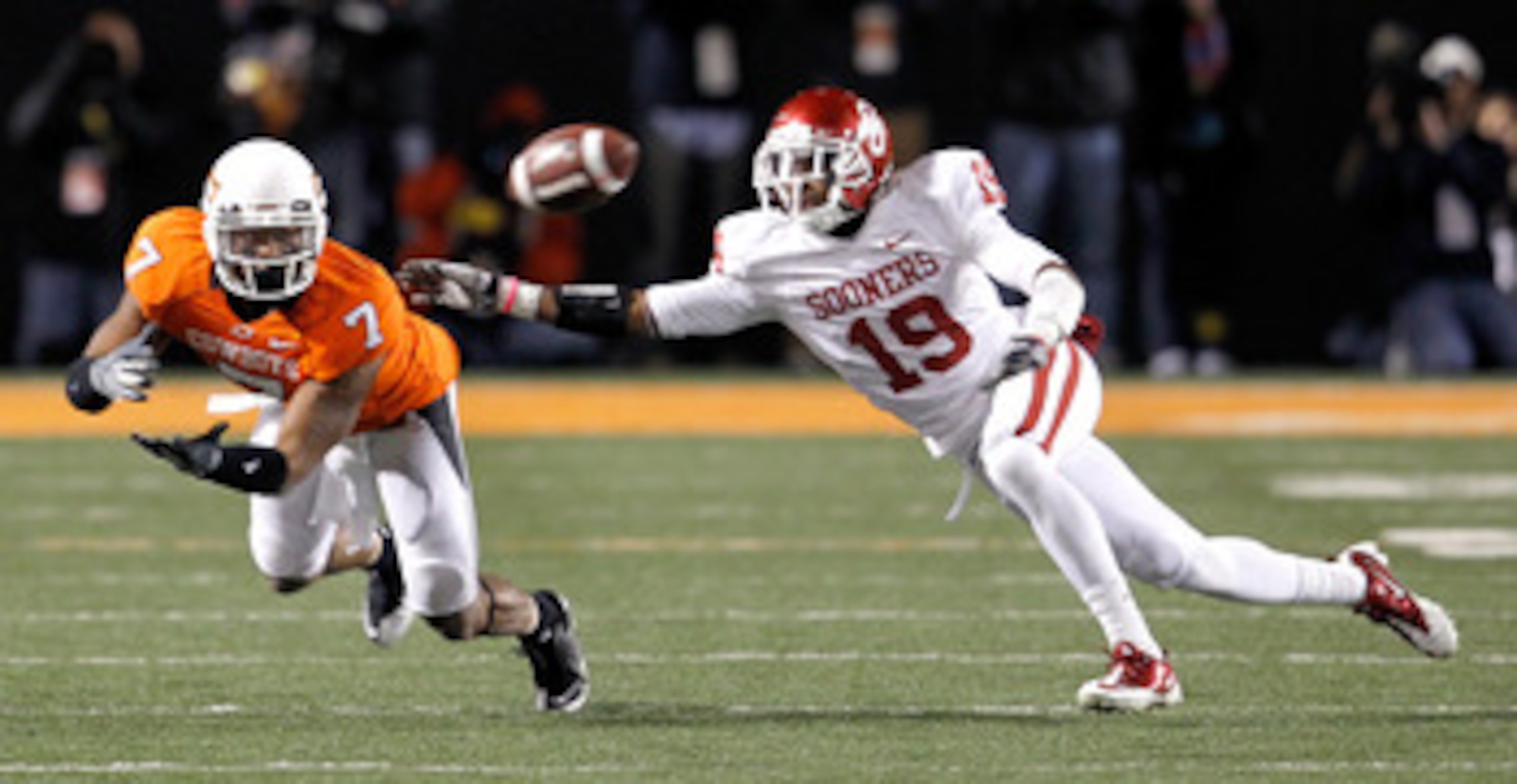 STILLWATER, OK - NOVEMBER 27: Receiver Michael Harrison #7 of the Oklahoma State Cowboys pulls in a pass against defensive back Demontre Hurst #19 of the Oklahoma Sooners at Boone Pickens Stadium on November 27, 2010 in Stillwater, Oklahoma. The Sooners STILLWATER, OK - NOVEMBER 27: Receiver Michael Harrison #7 of the Oklahoma State Cowboys pulls in a pass against defensive back Demontre Hurst #19 of the Oklahoma Sooners at Boone Pickens Stadium on November 27, 2010 in Stillwater, Oklahoma. The Sooners