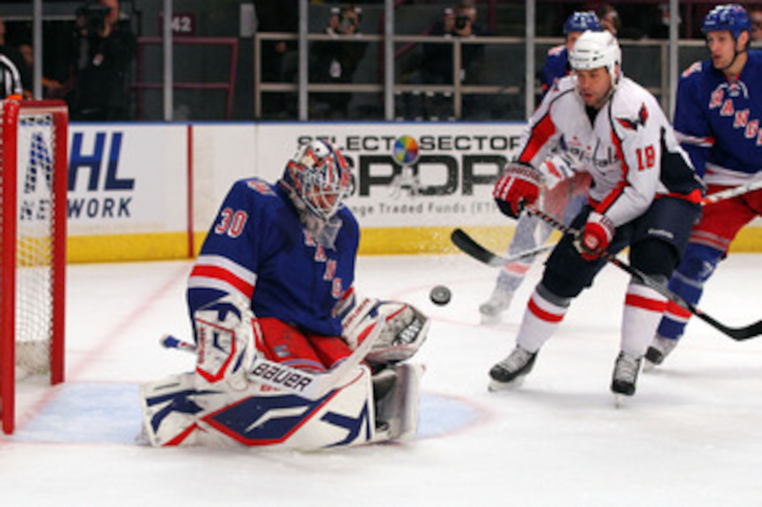 NEW YORK, NY - APRIL 17:  Goalie Henrik Lundqvist #30 of the New York Rangers makes a save against Marco Sturm #18 of the Washington Capitals in Game Three of the Eastern Conference Quarterfinals during the 2011 NHL Stanley Cup Playoffs at Madison Square