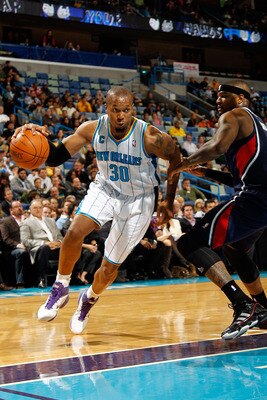 NEW ORLEANS, LA - DECEMBER 26:  David West #30 of the New Orleans Hornets drives the ball around Josh Smith #5 of the Atlanta Hawks at the New Orleans Arena on December 26, 2010 in New Orleans, Louisiana.  The Hornets defeated the Hawks 93-86.  NOTE TO US