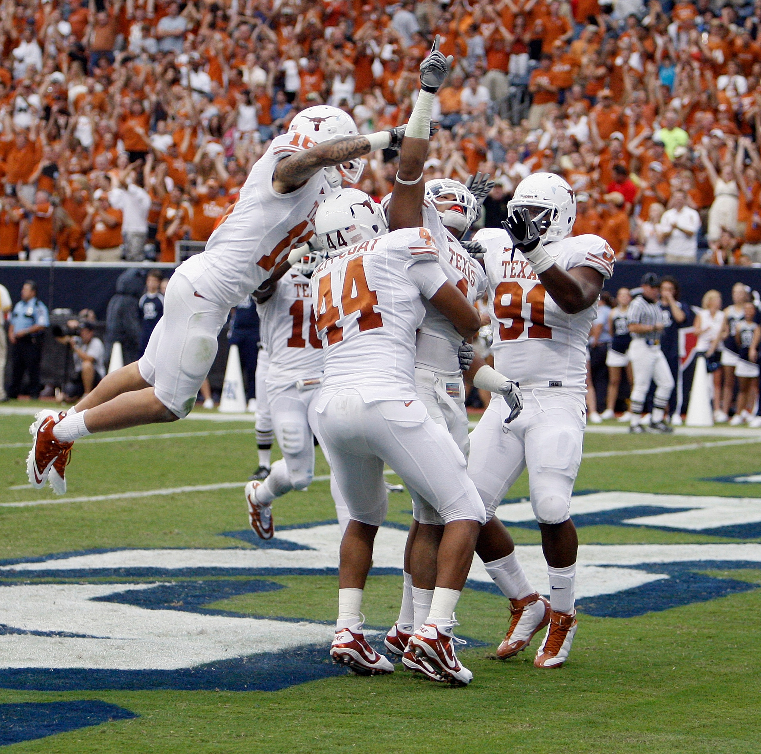 HOUSTON - SEPTEMBER 04:  Safety Kenny Vacarro #16 of the Texas Longhorns along with Jackson Jeffcoat #44 and Kheeston Randall #92 jumps on the back of linebacker Keenan Robinson #1 who recovered a fumble and scored against the Rice Owls at Reliant Stadium