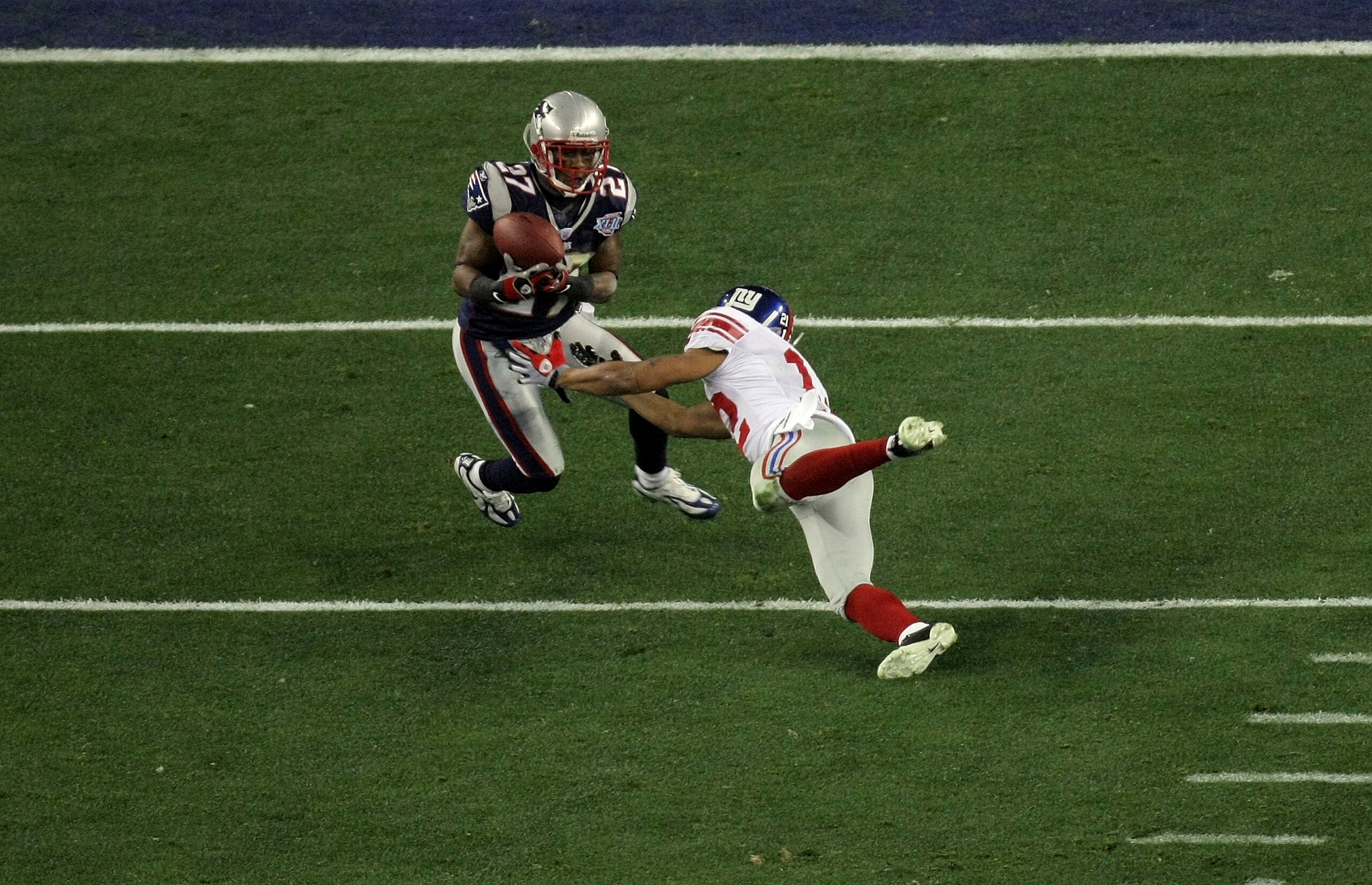 GLENDALE, AZ - FEBRUARY 03:  Ellis Hobbs III #27 of the New England Patriots intercepts a pass in the second quarter against Steve Smith #12 of the New York Giants during Super Bowl XLII on February 3, 2008 at the University of Phoenix Stadium in Glendale