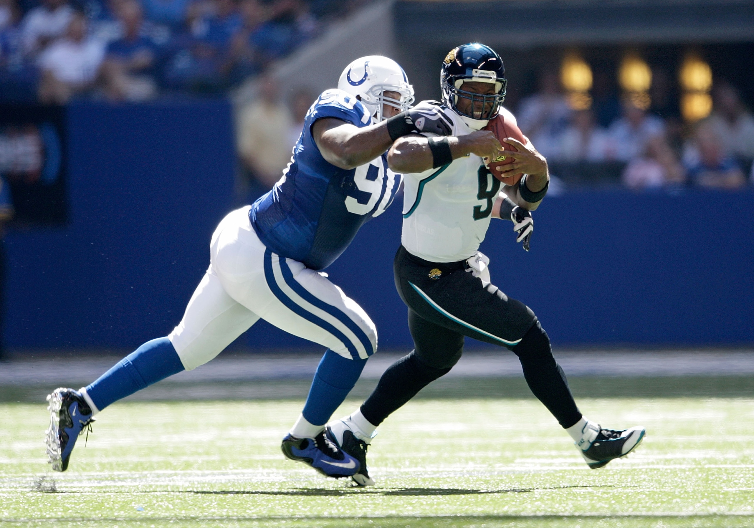INDIANAPOLIS - SEPTEMBER 13:  David Garrard #9 of the Jacksonville Jaguars runs with the ball while defended by Daniel Muir #90 of the Indianapolis Colts during the game at Lucas Oil Stadium on September 13, 2009 in Indianapolis, Indiana.  (Photo by Andy