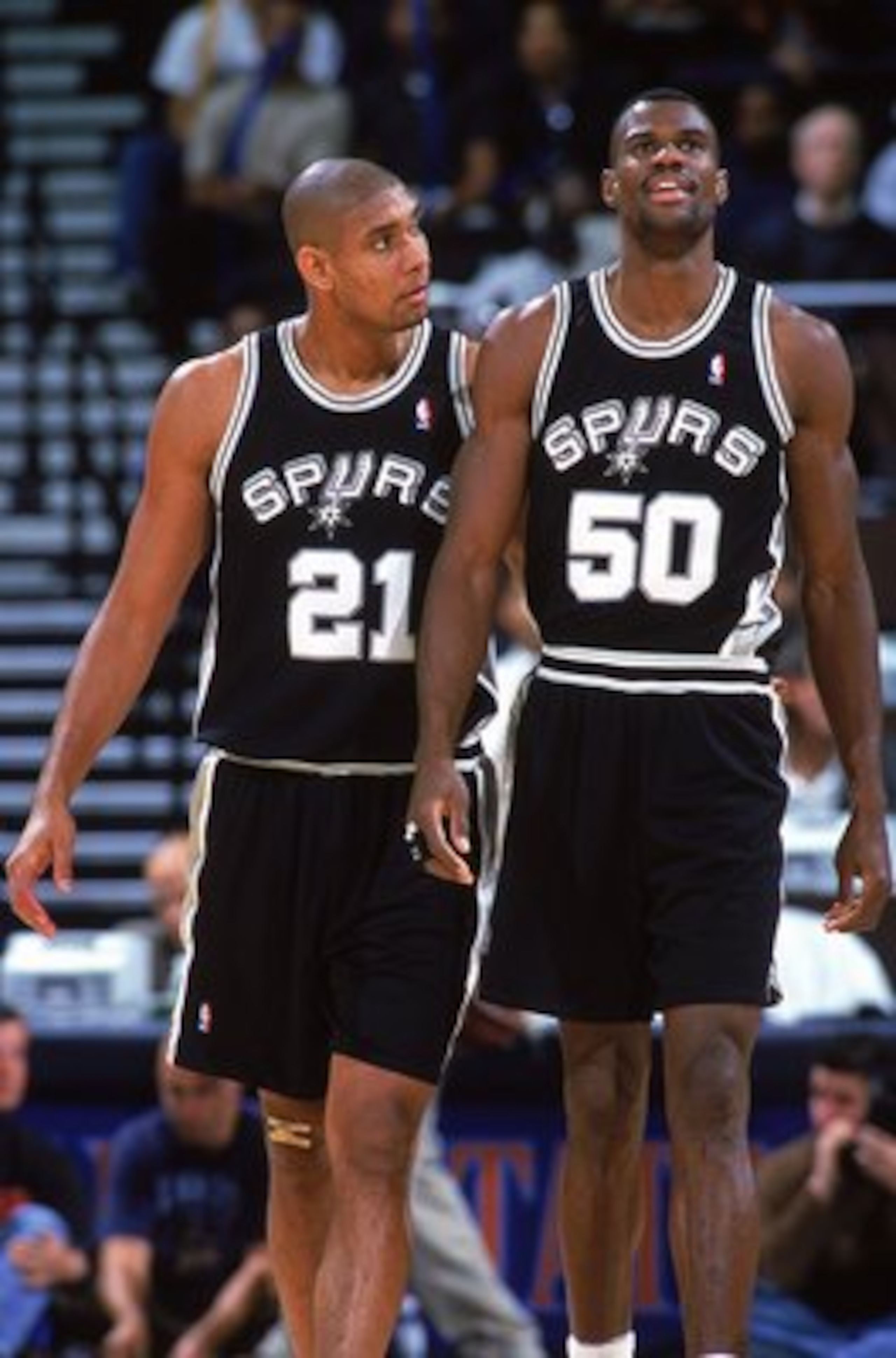 9 Nov 1999: David Robinson #50 of the San Antonio Spurs walks on the court with teammate Tim Duncan #21during a game against the Golden State Warriors at the Oakland Coliseum in Oakland, California. The Spurs defeated the Warriors 118-89.  Mandatory Credi