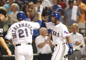 ARLINGTON, TX - JULY 20:  Elvis Andrus #1 of the Texas Rangers celebrates with a high-five with teammate Jarrod Saltalamacchia #21 after Saltalamacchia hit a home run in the sixth inning against pitcher John Smoltz (not in photo) during the MLB game at Ra