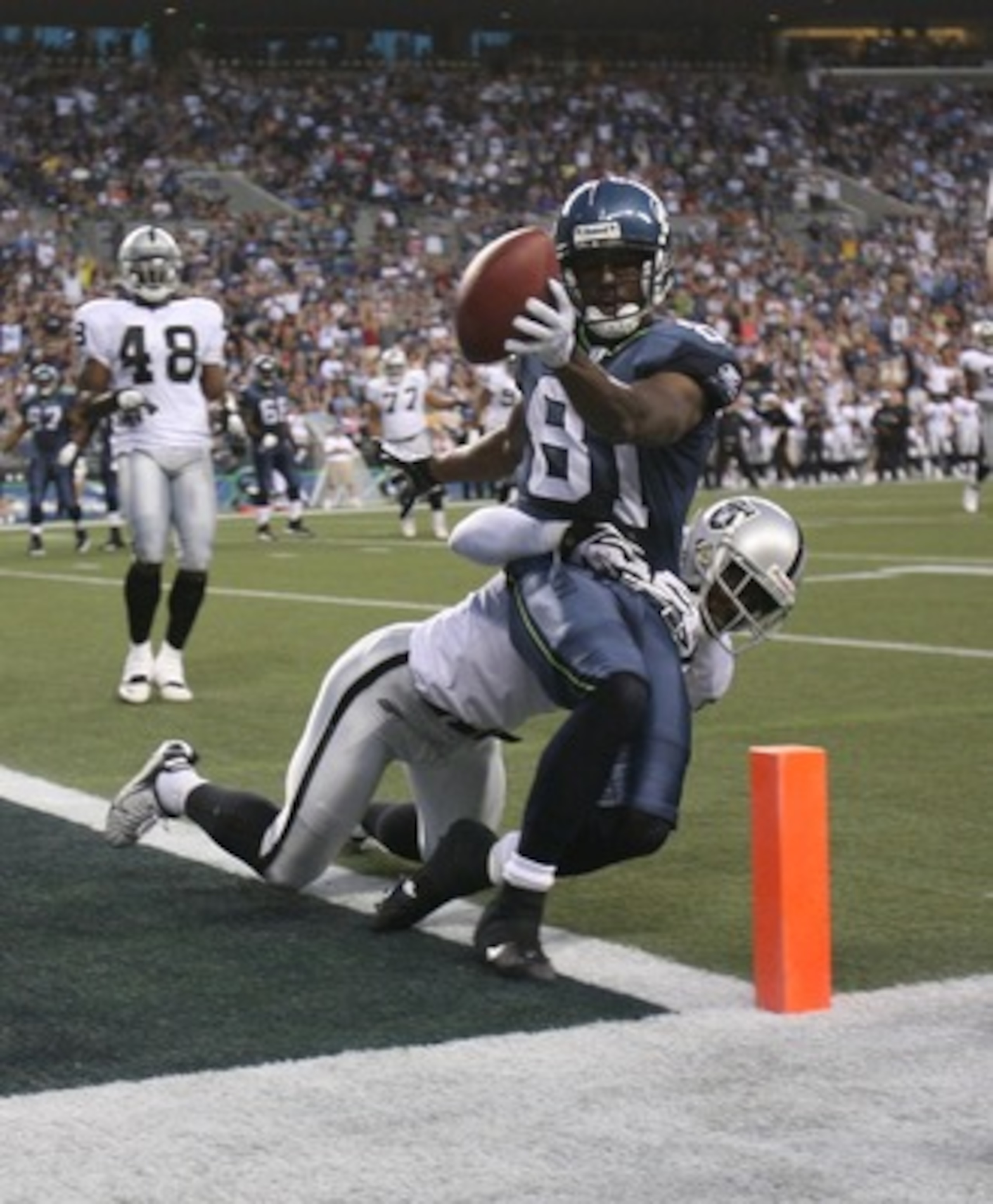 SEATTLE - AUGUST 30: Wide receiver Nate Burleson #81 of the Seattle Seahawks scores a touchdown against Hiram Eugene #31 of the Oakland Raiders in a preseason game at Qwest Field August 30, 2007 in Seattle, Washington. (Photo by Otto Greule Jr/Getty Imag SEATTLE - AUGUST 30: Wide receiver Nate Burleson #81 of the Seattle Seahawks scores a touchdown against Hiram Eugene #31 of the Oakland Raiders in a preseason game at Qwest Field August 30, 2007 in Seattle, Washington. (Photo by Otto Greule Jr/Getty Imag